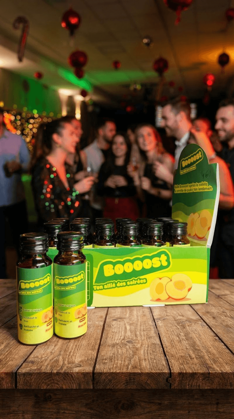 Vue d'un stand Boooost installé dans un club, avec des bouteilles alignées sur un comptoir éclairé, une affiche de la marque en arrière-plan et un verre de dégustation, capturant l'ambiance nocturne et festive.
