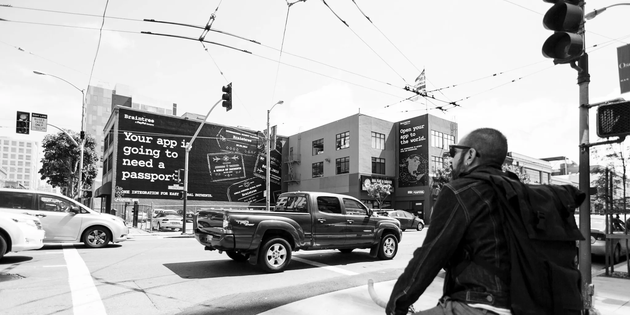 a man walking down a street past a large poster