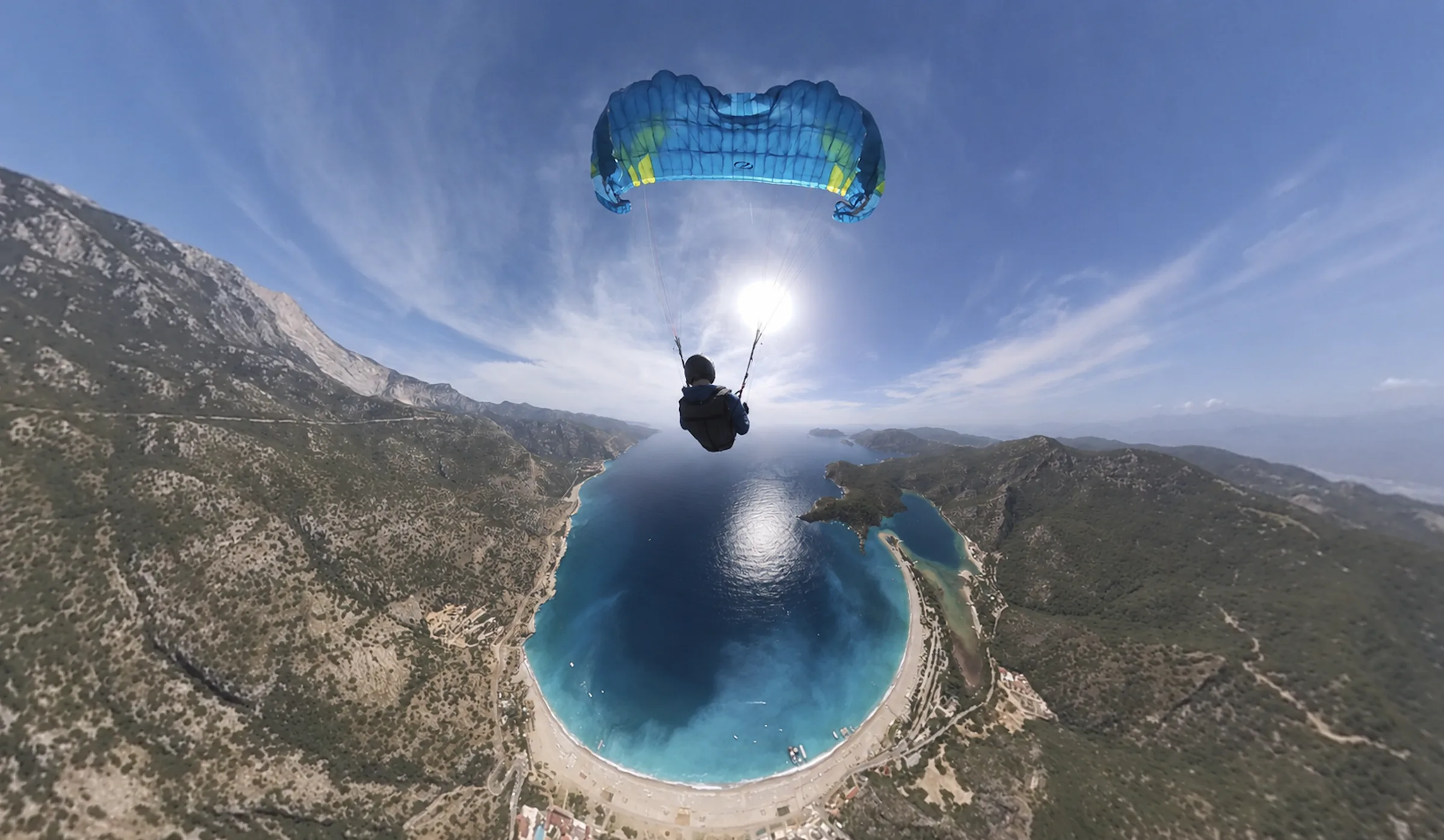 Blue paraglider overhead during stall training