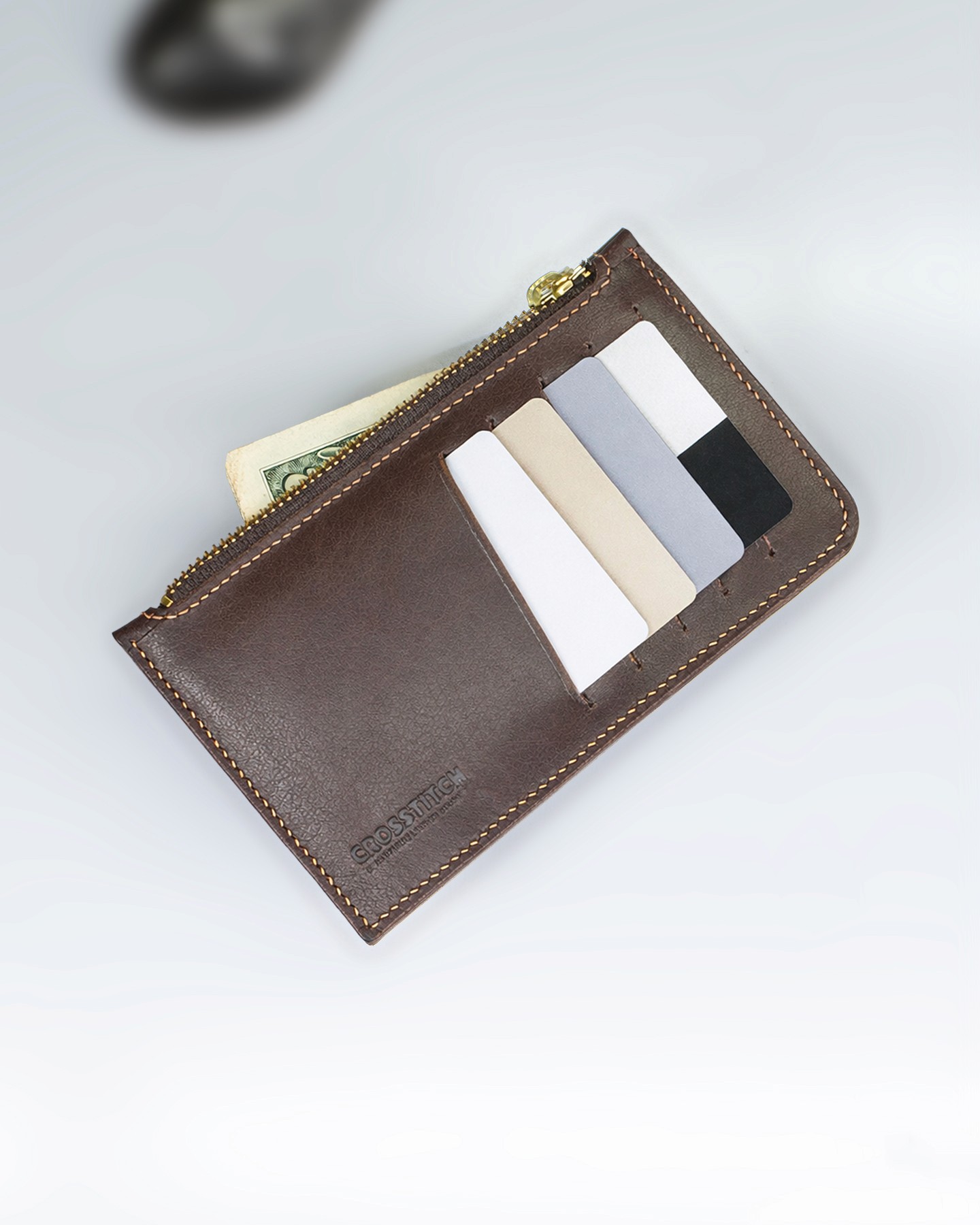 Crosstitch Leather money envelope with cash and cards inside, made from full-grain brown leather with handcrafted stitching.