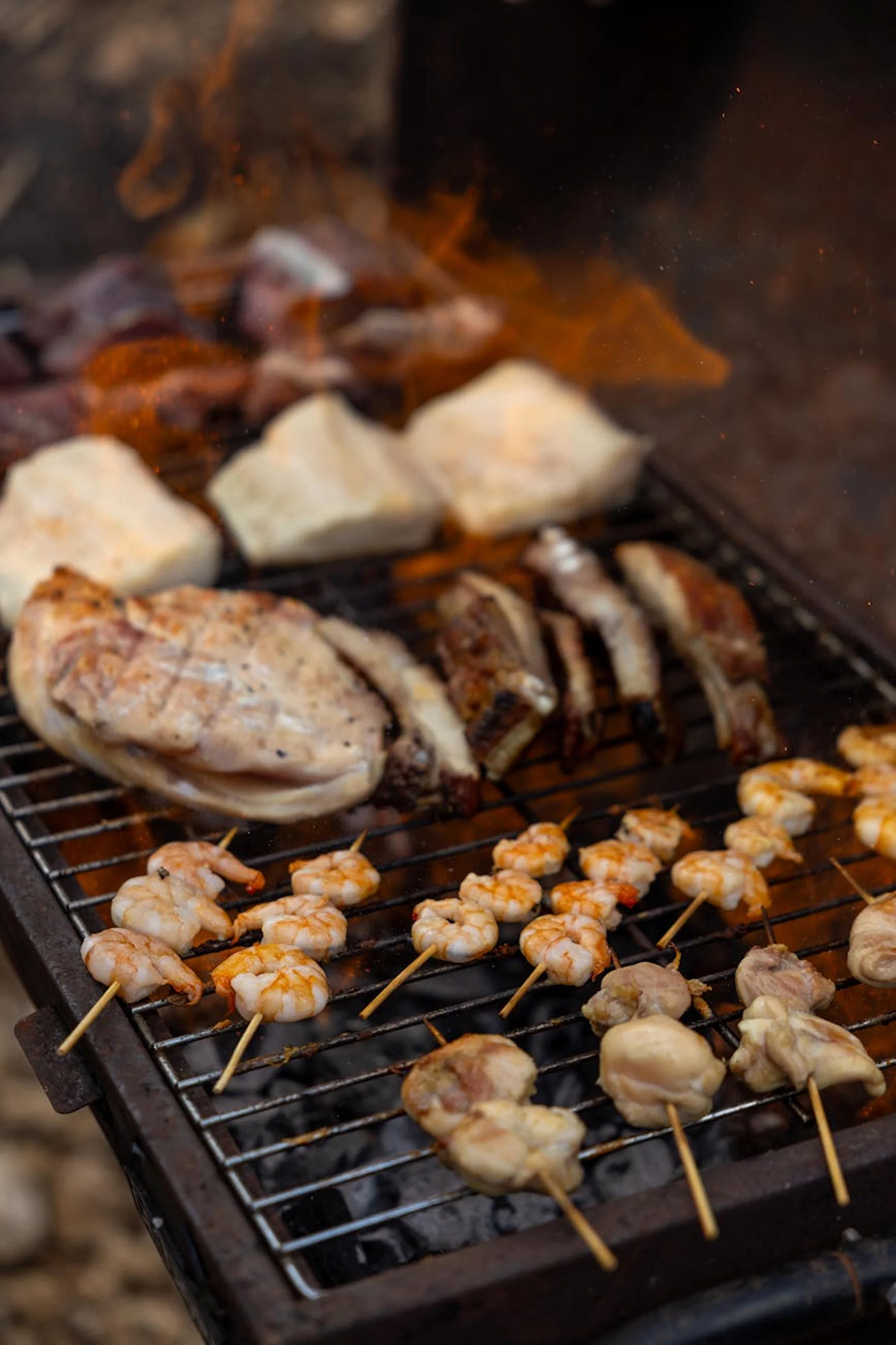 Beachside BBQ setup with grilled food and outdoor dining near the sea.