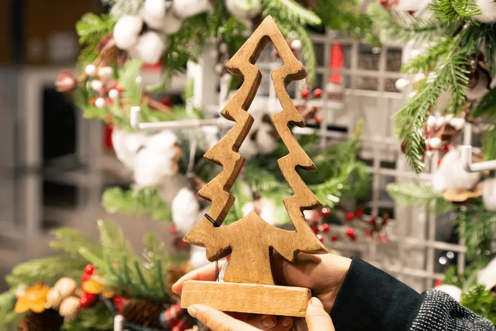 Hands holding a wooden Christmas tree decoration