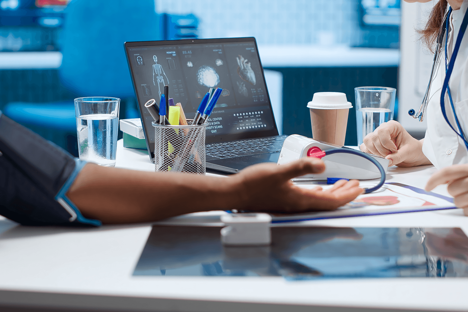 A doctor reviewing patient data and device readings on a laptop, representing risk management in medical device development and what every startup should know.