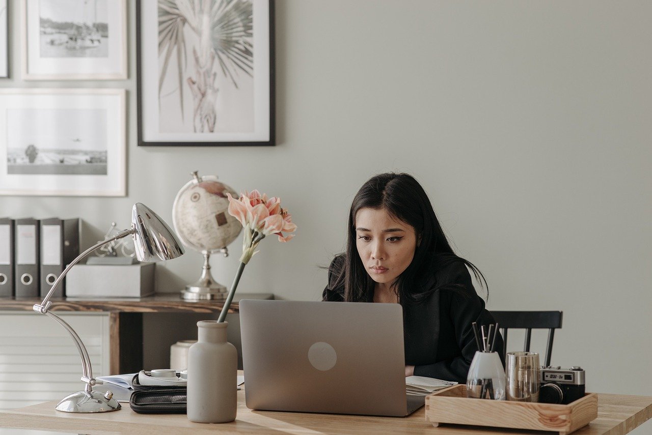 a woman sitting at a desk typing on a computer, heso blog image
