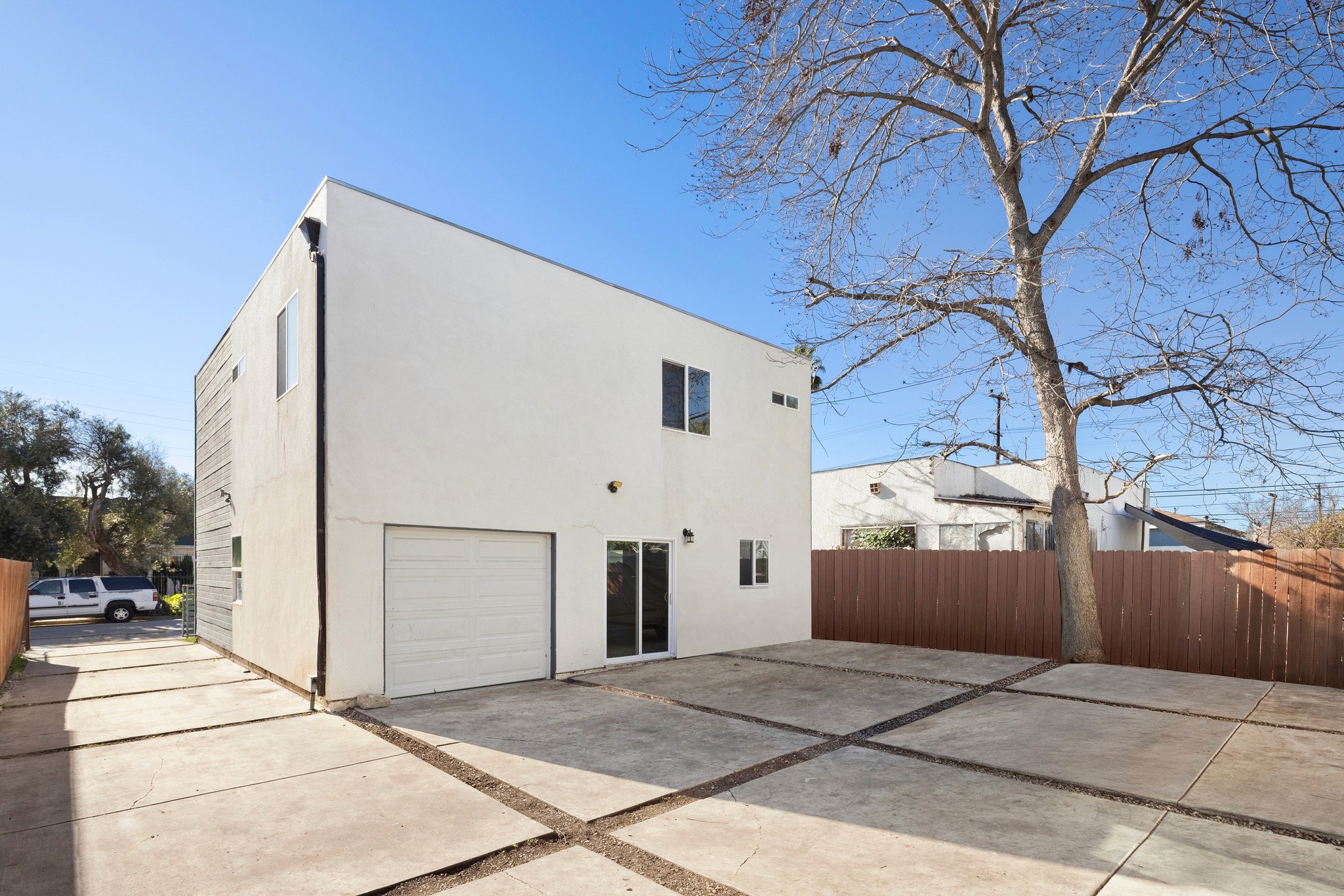 Exterior side view of modern triplex with clean architectural lines and private driveway at 645 west 97th street.