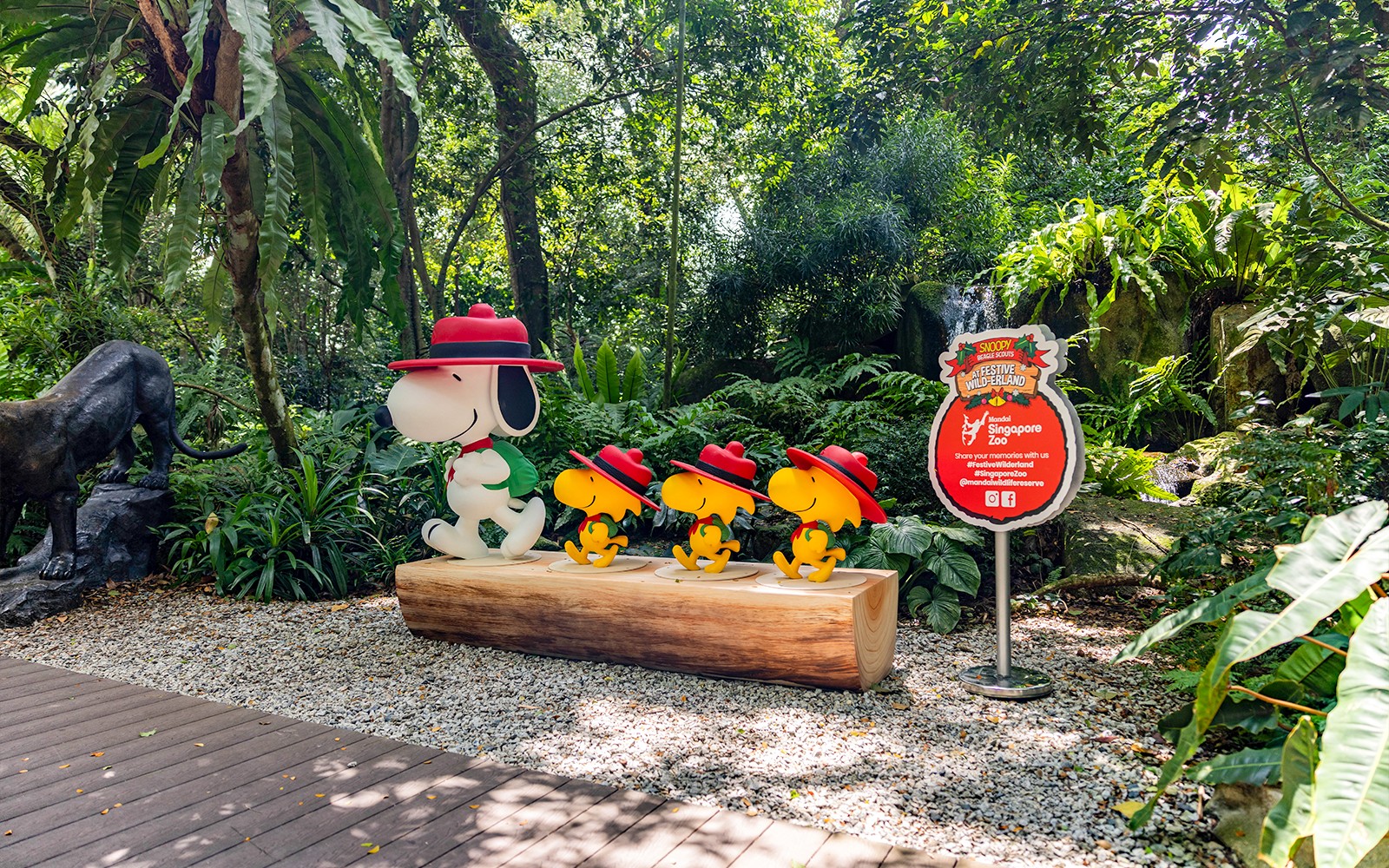 Statues de Snoopy et des Beagle Scouts au Zoo de Singapour au milieu d'une verdure luxuriante.
