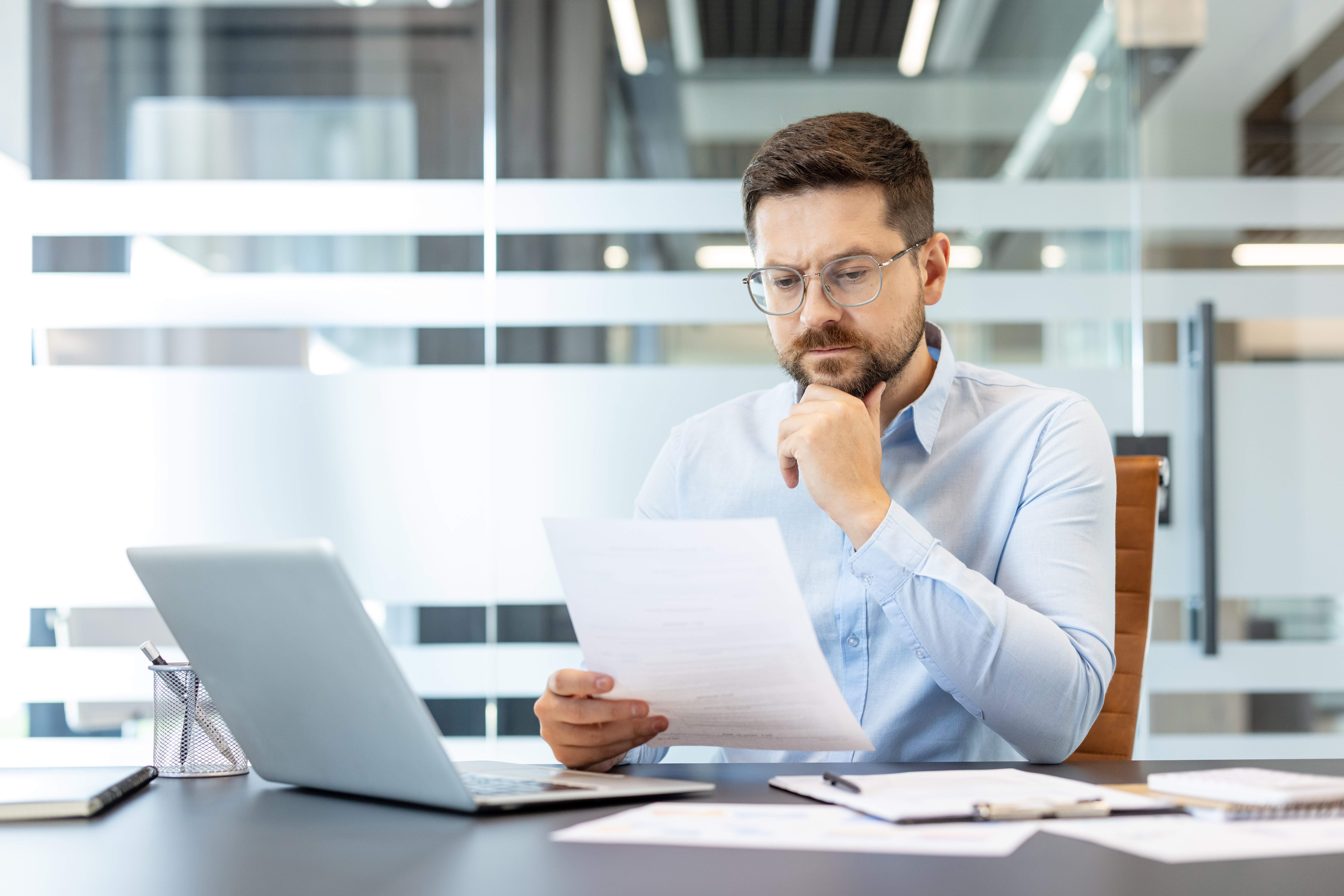Experienced private lender carefully reviewing loan documents and property details"