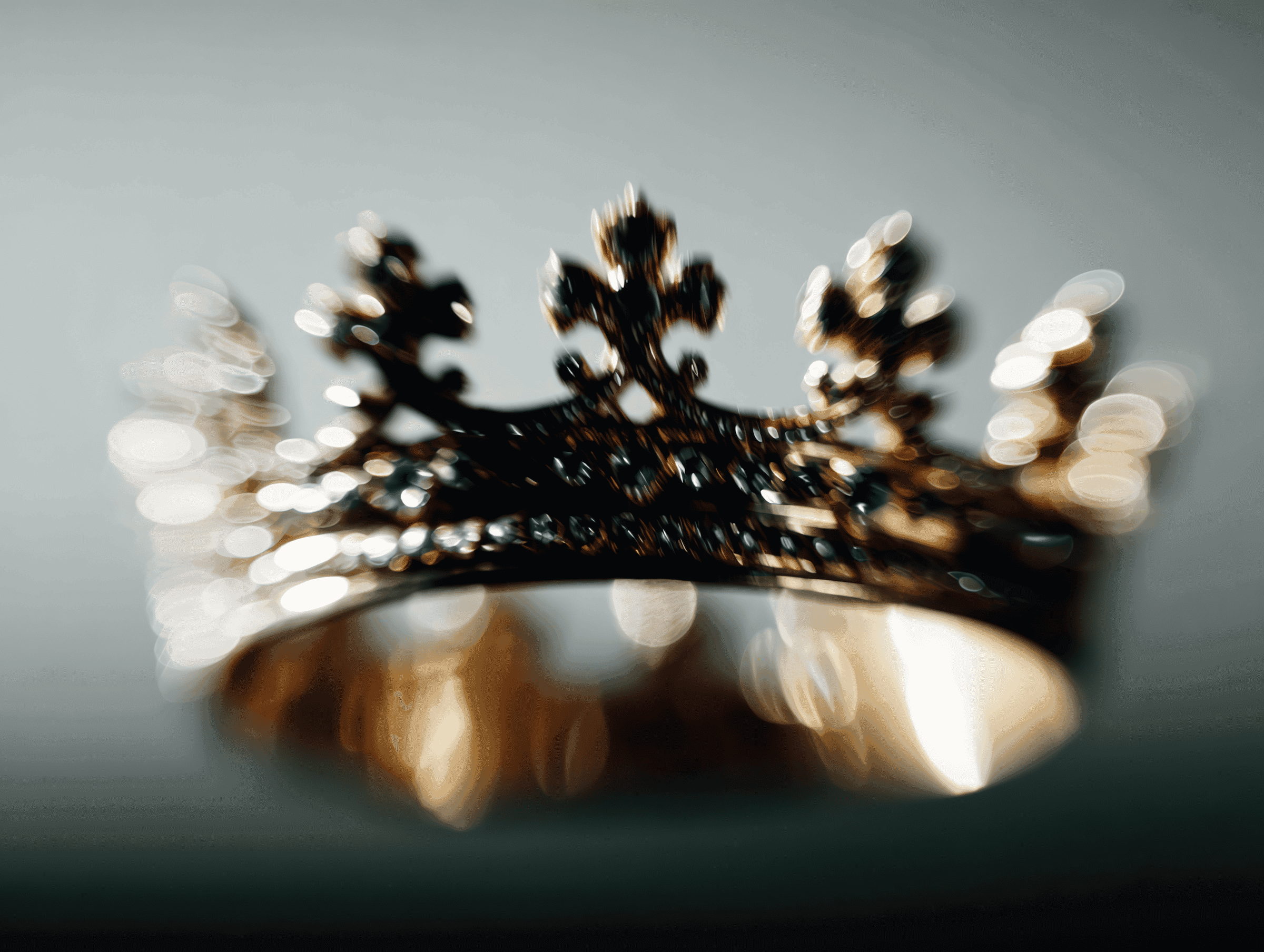 Golden crown in shallow focus against a neutral background