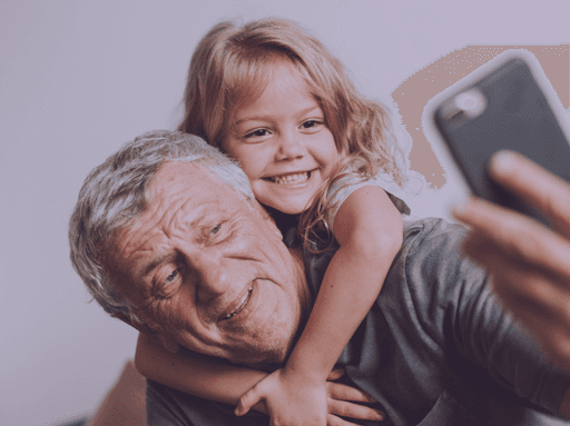 Grandfather and granddaughter recording a video to upload to Glimpse, creating a lasting memory.