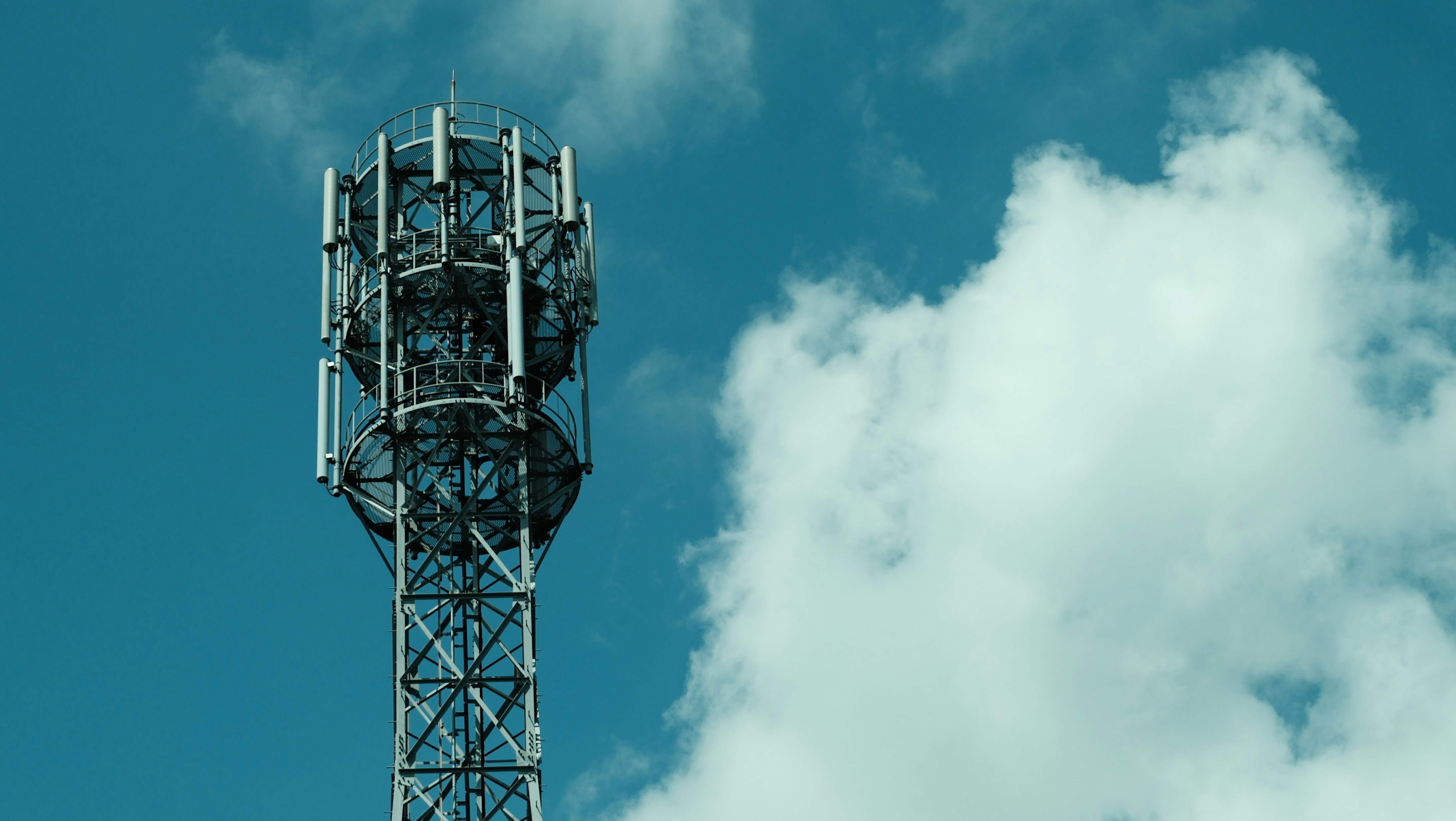 Cell tower against a cloudy blue sky