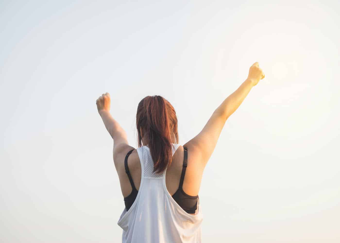 Wellbeing apps - woman holding her hands up to the sky