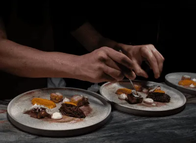 Desserts with whipped cream and nuts served on small plates.