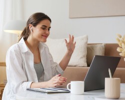 A woman smiling while using her laptop