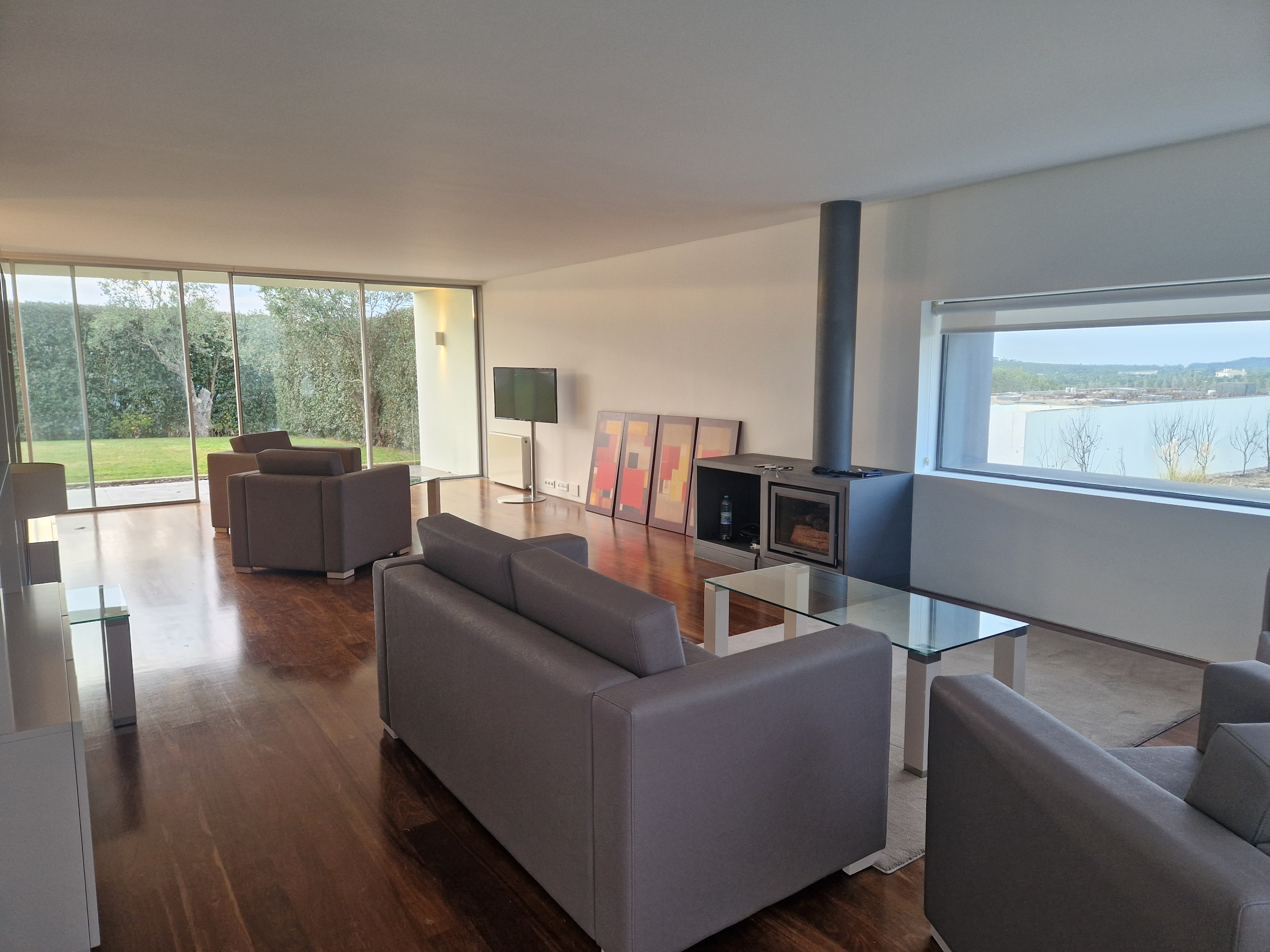 Modern kitchen and dining area with wood cabinets and large windows