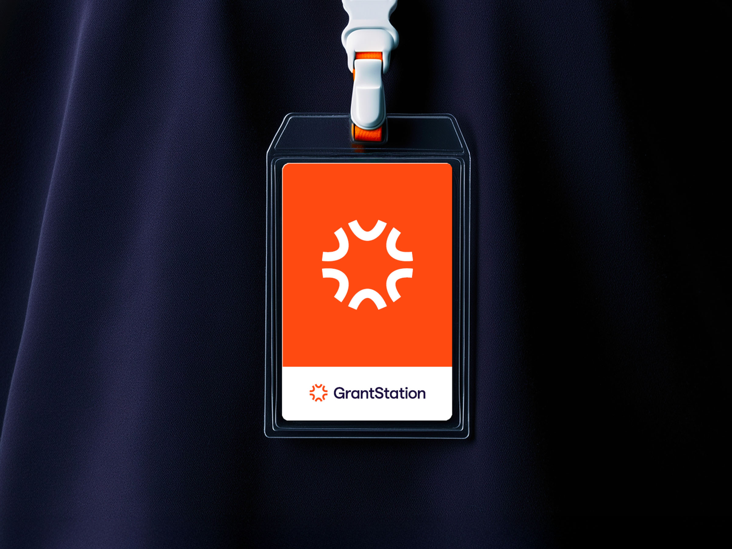 GrantStation ID badge featuring the orange symbol and logo on a dark fabric background.