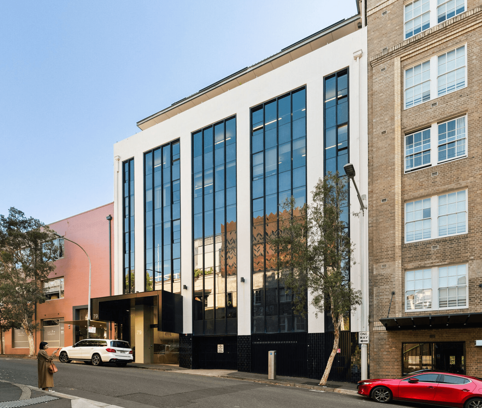 Brown sculptural leather handbag resting on tall ornamental grass during golden hour, evoking a natural, elegant mood.