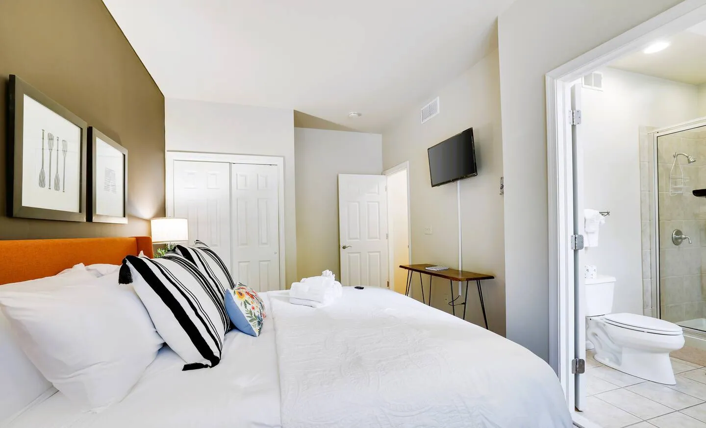 King bedroom with white bedding and doorway to the ensuite bath at Pop's Place