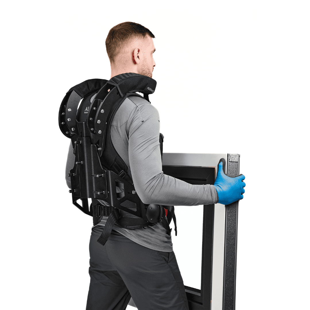 Man using the CarrySuit to carry a heavy load, designed to relieve shoulders and back during physical work.