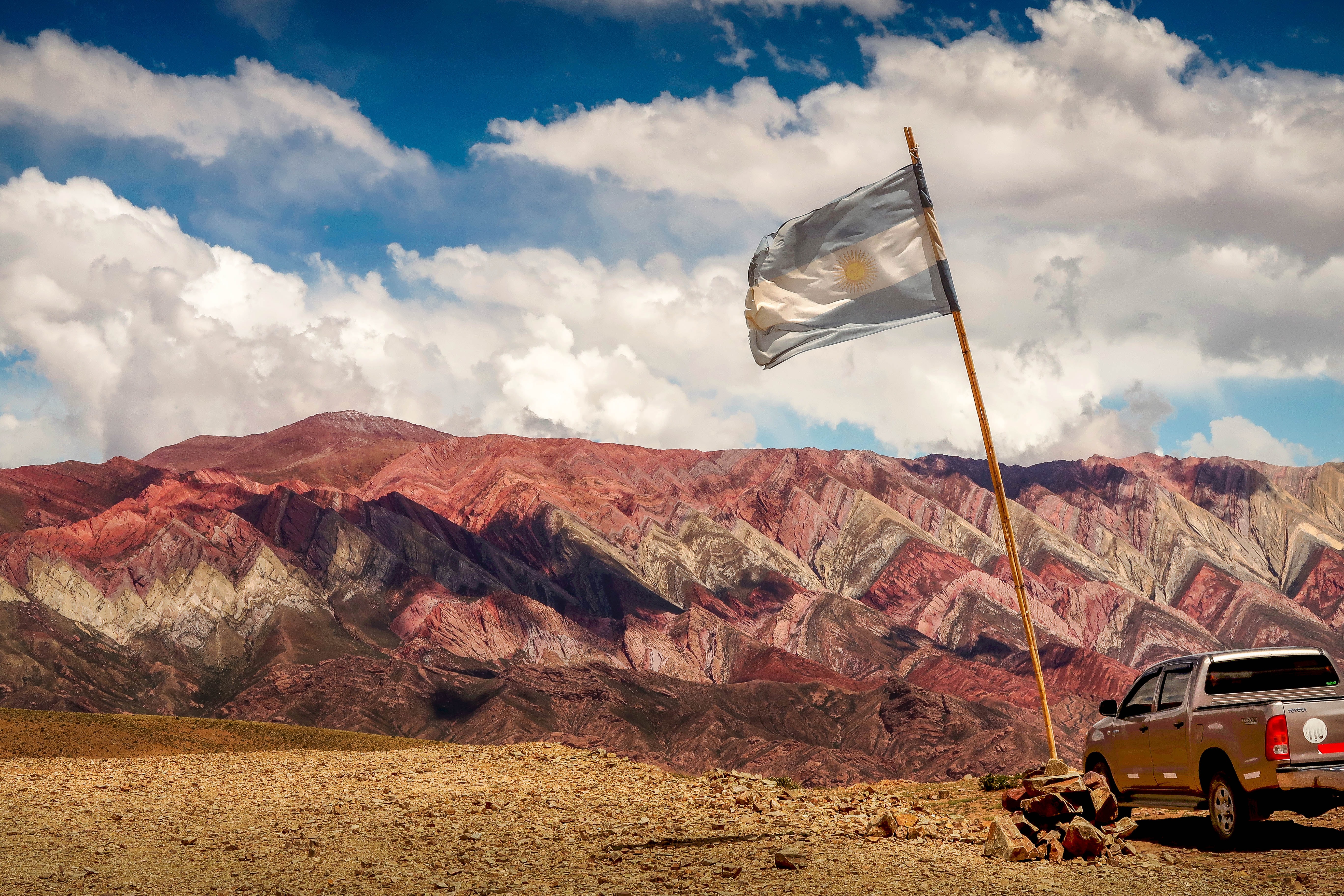 Argentinian flag against the multicolored mountains of Jujuy