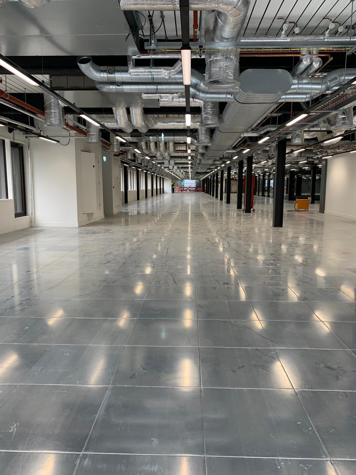 A geometric, multi-tiered modern home with clean lines, floor-to-ceiling windows, and wooden accents in a serene, foggy landscape.