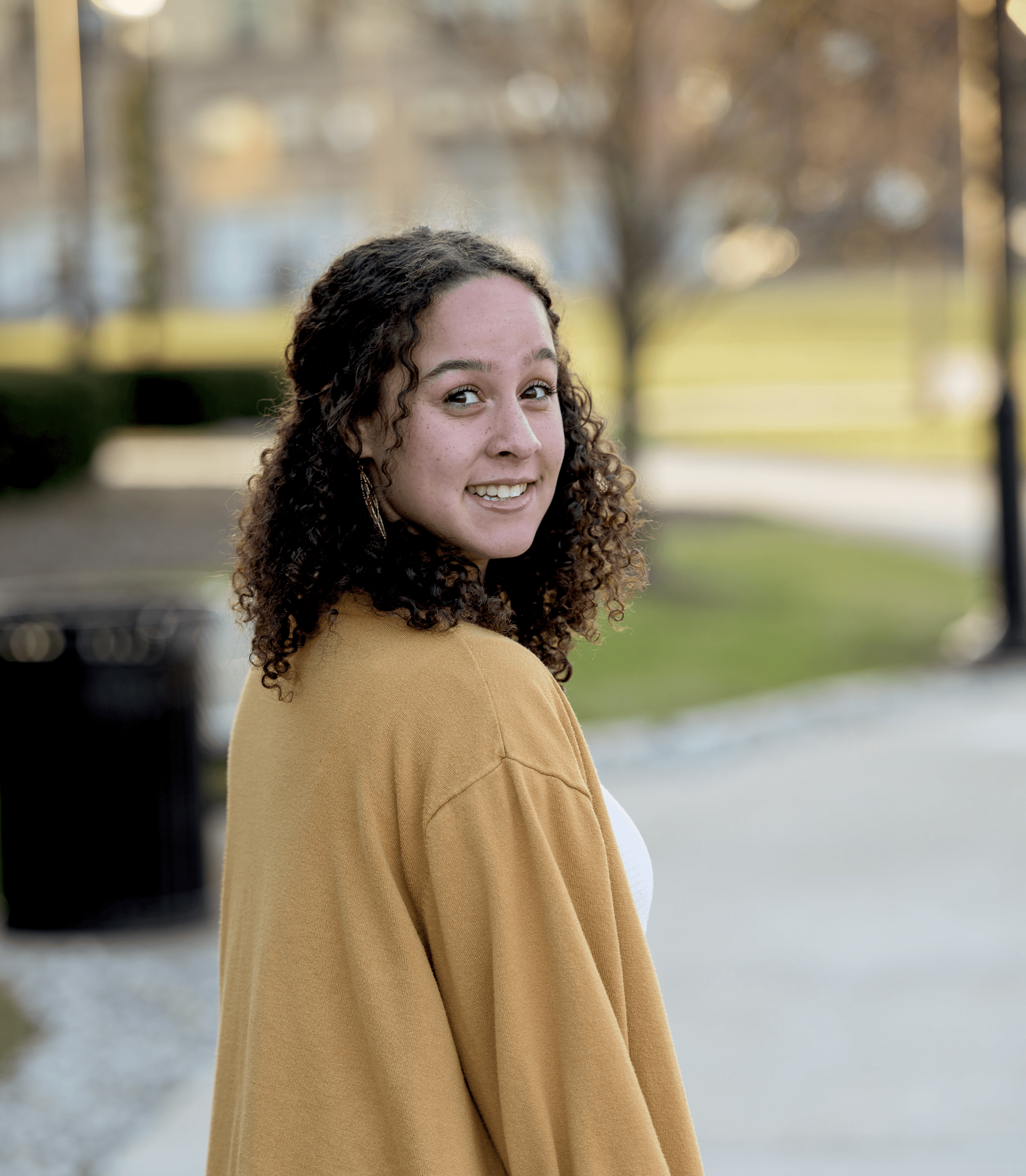 Colpo verticale di una femmina bianca attraente che sorride alla macchina fotografica