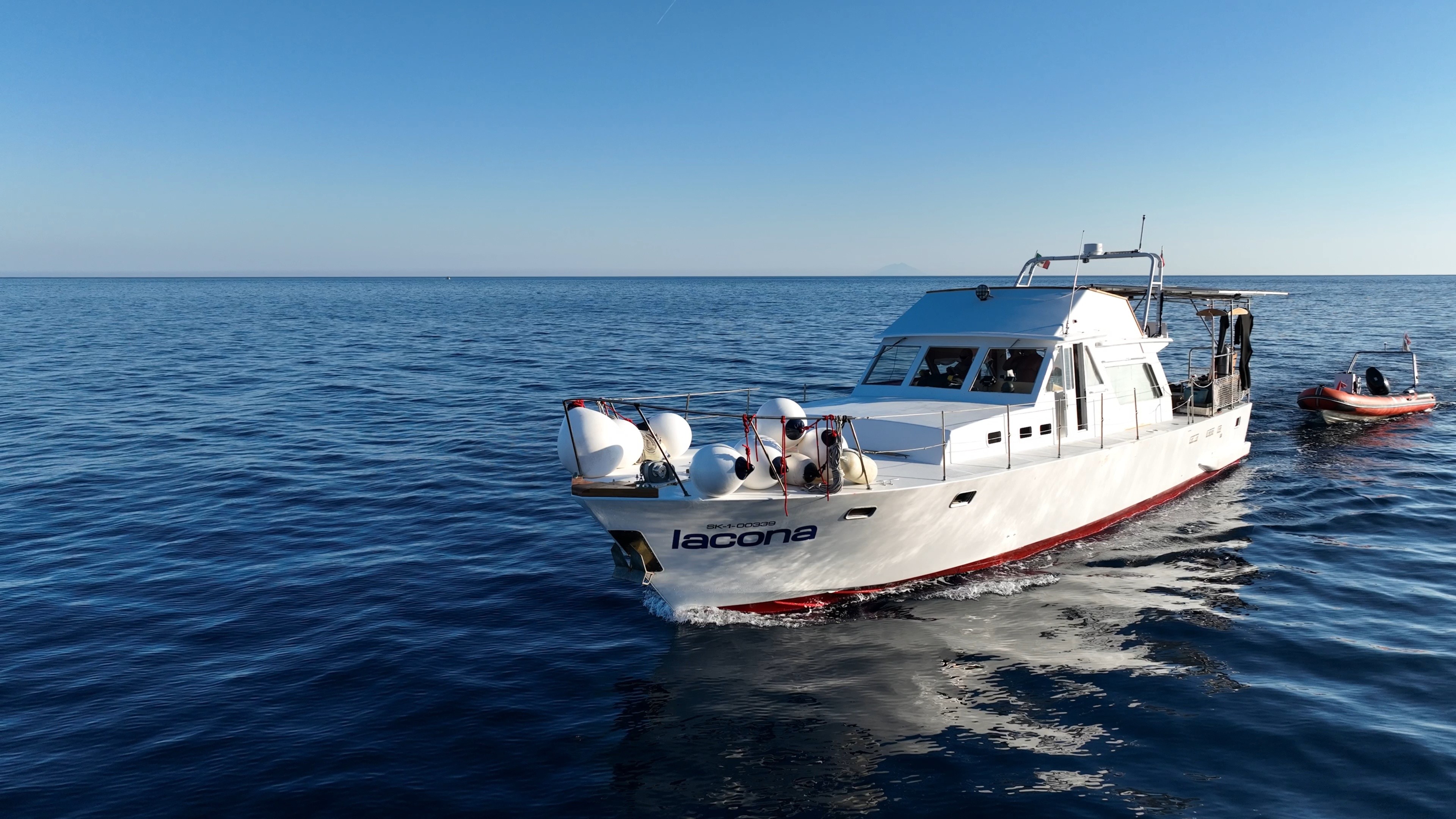 a woman scubas over a colorful coral reef