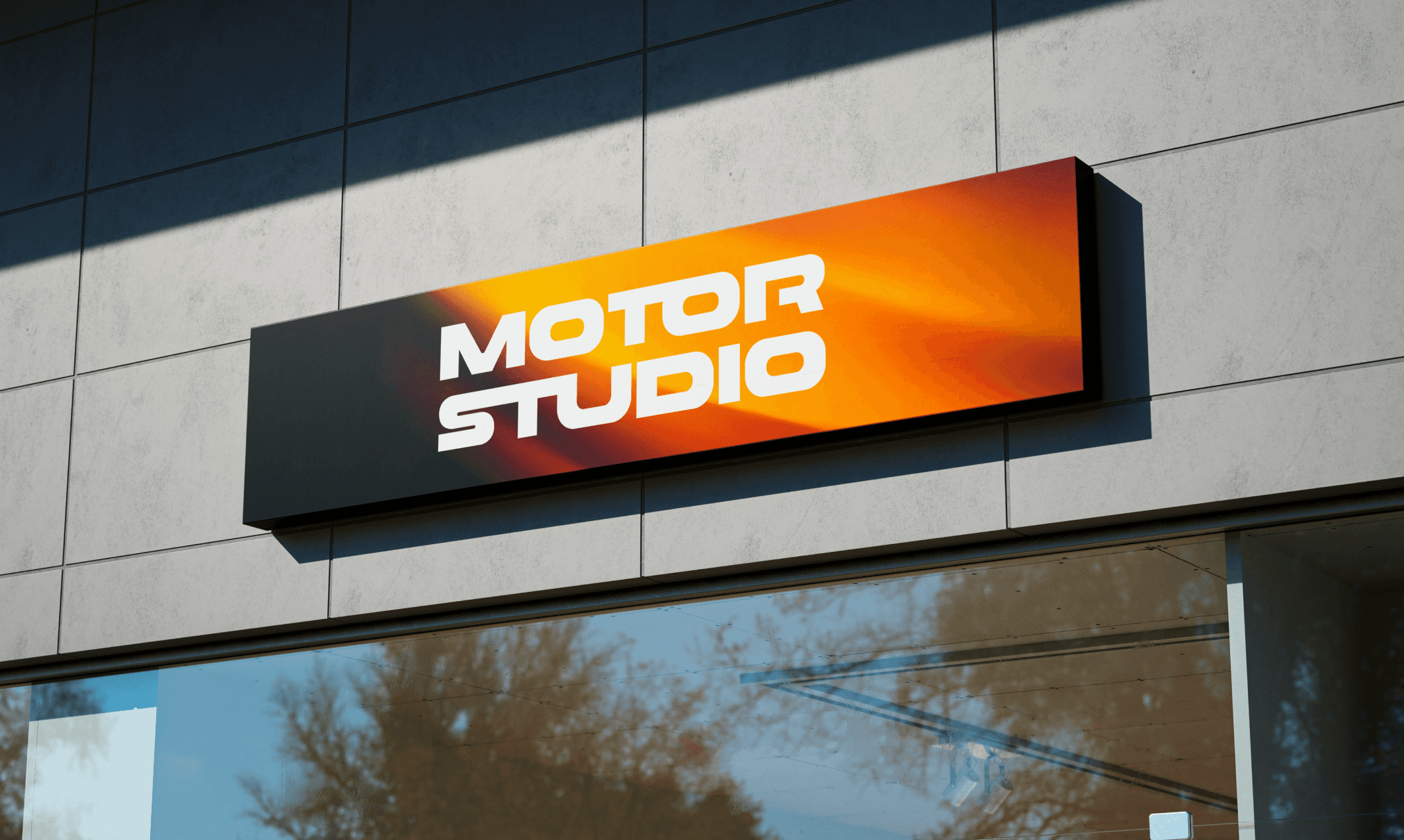 Enseigne extérieure du showroom Motor Studio, avec logo blanc sur fond orange dégradé.