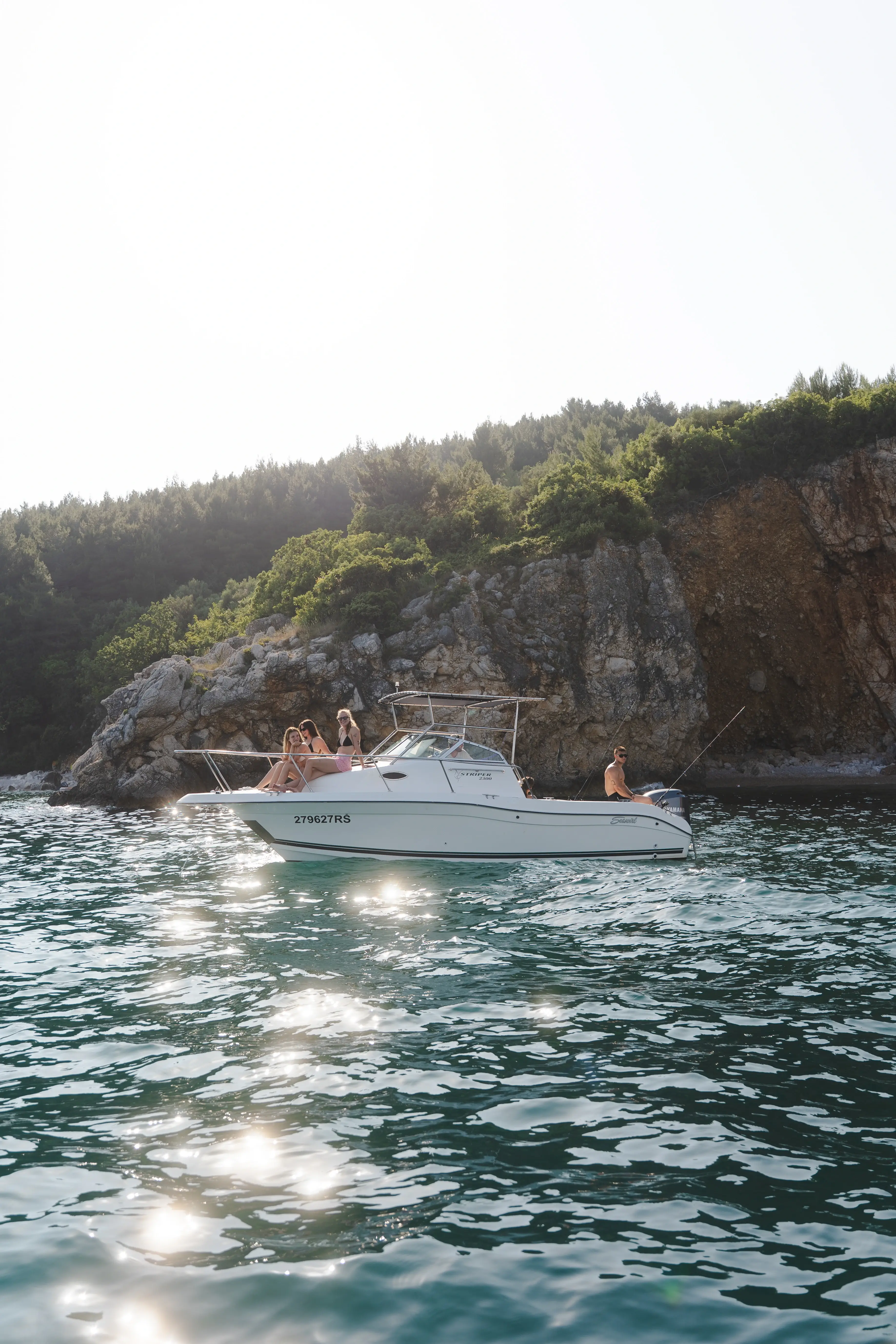 Speedboat with friends enjoying a private boat tour near rocky cliffs on the Adriatic Sea in Croatia.