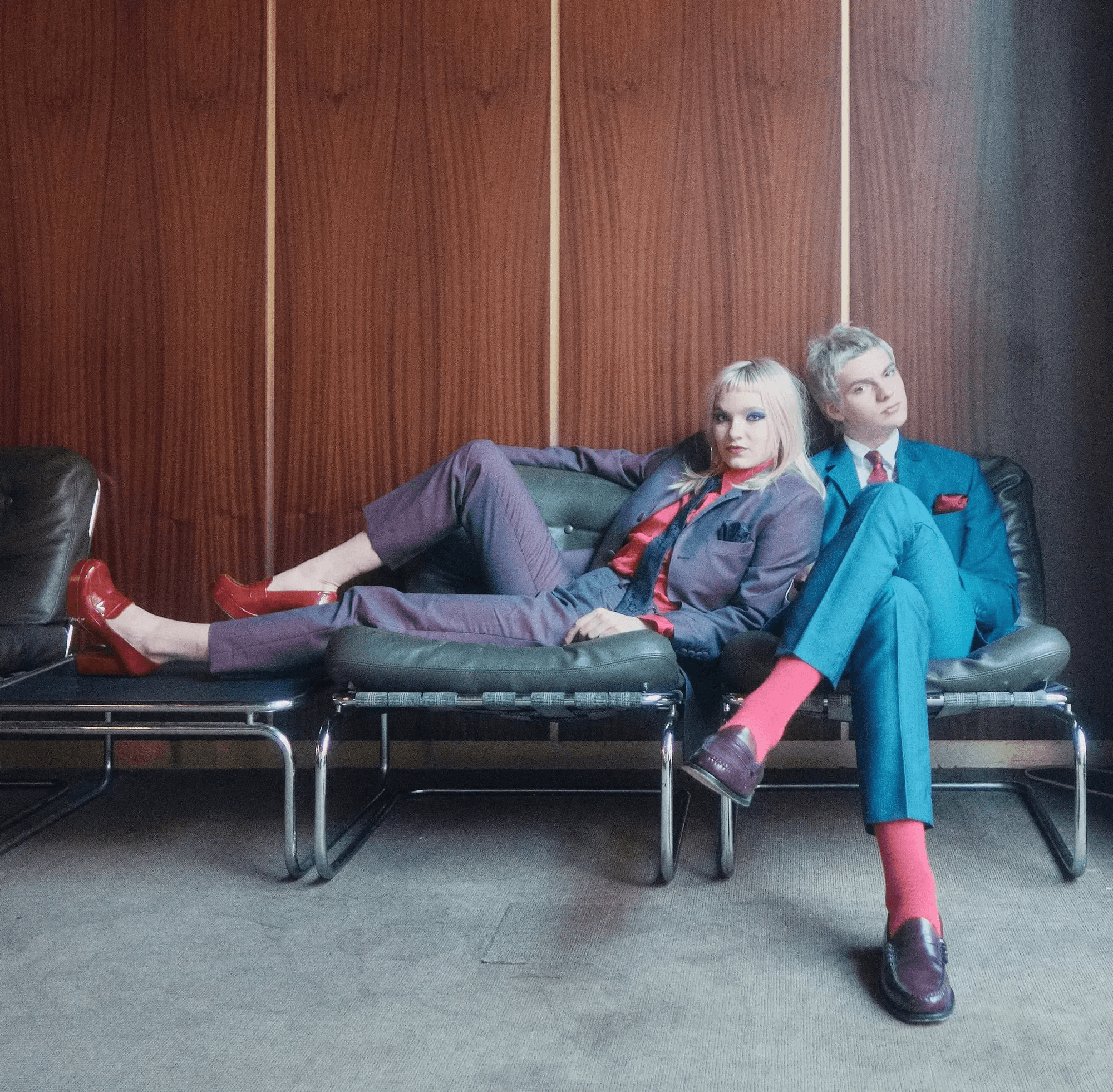 A modern brick house with a two-car garage, well-manicured lawn, and clear blue sky in the background.
