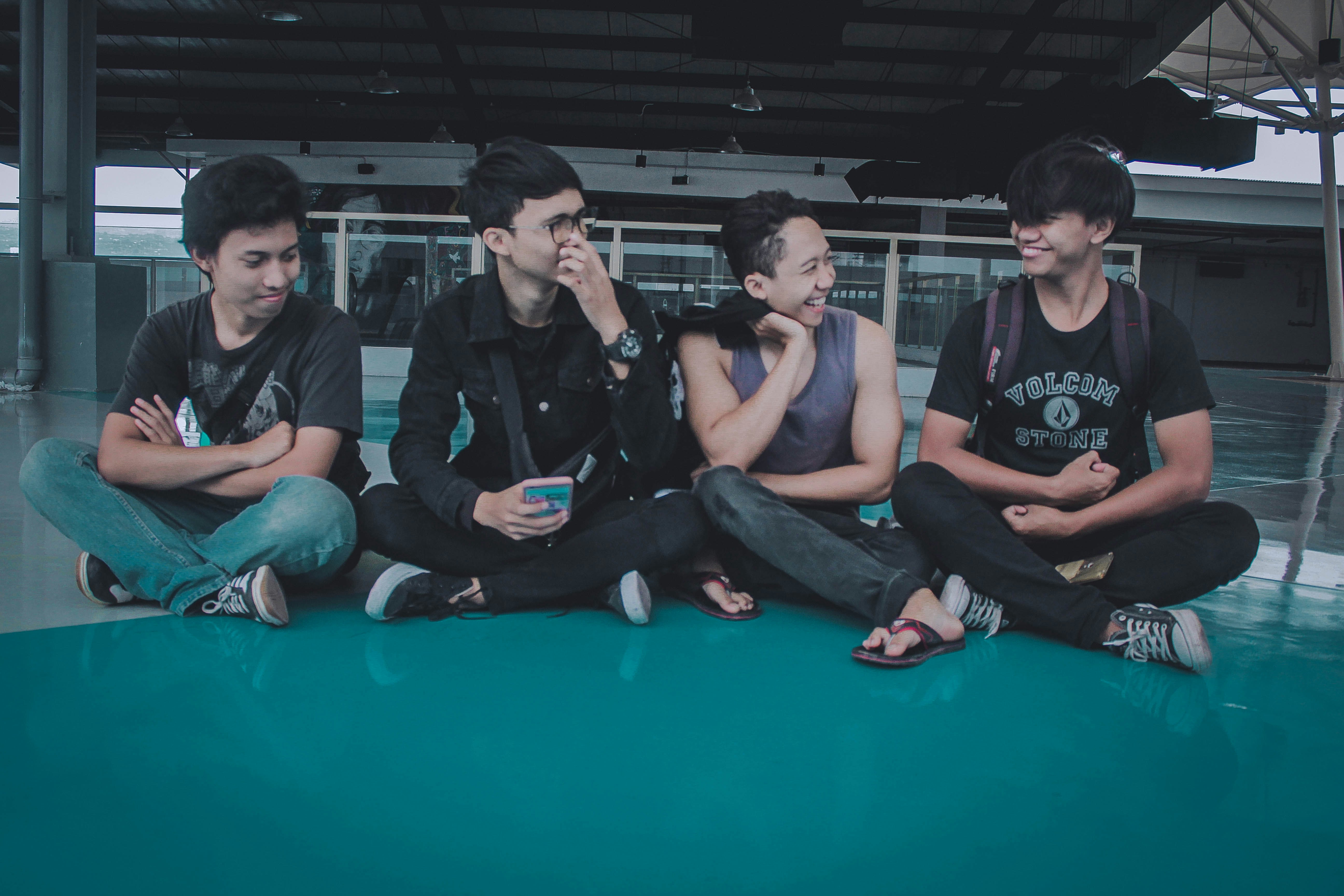 3 men sitting on green floor