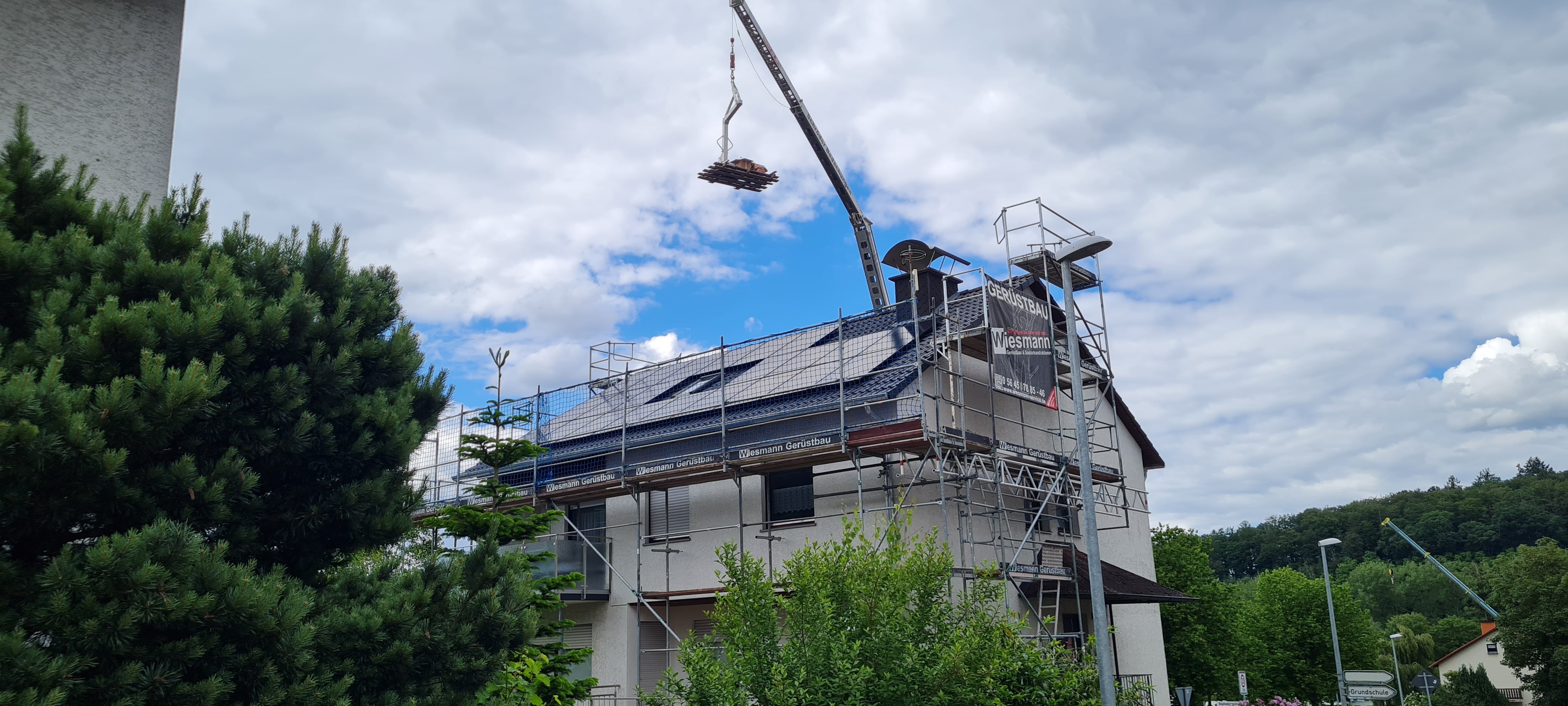 Dach mit PV-Anlage und einem Kran, mit dem Solarmodule hochgefahren werden in Wesertal
