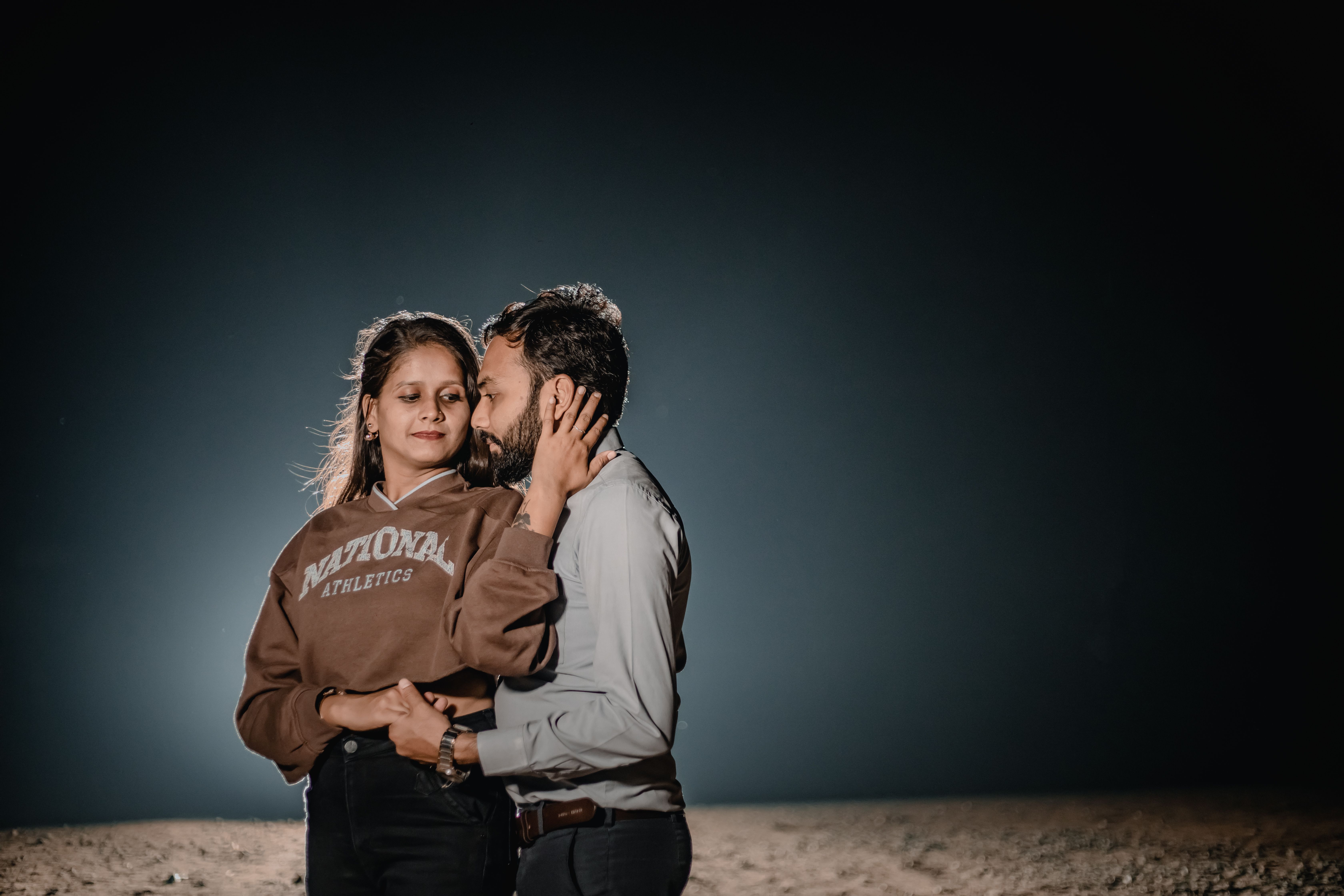 Couple embracing on a beach at night
