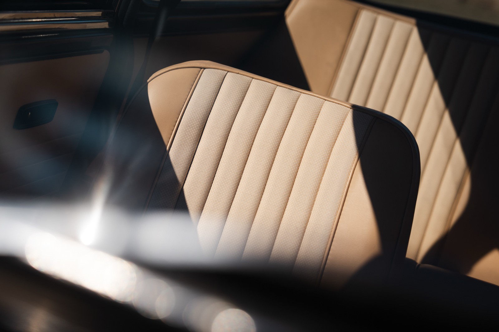 Close-up of car interior seats featuring a modern design with textured patterns in light and dark colors.