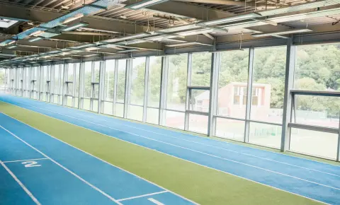 Indoor running track with marked lanes inside a modern sports facility showing standard indoor track design
