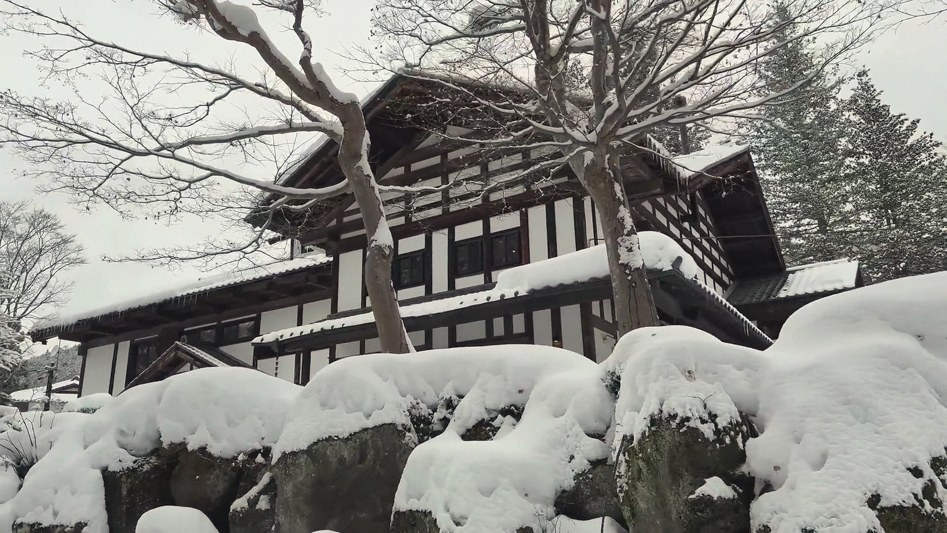 Wooden building in the Jigokudani valley under deep snow