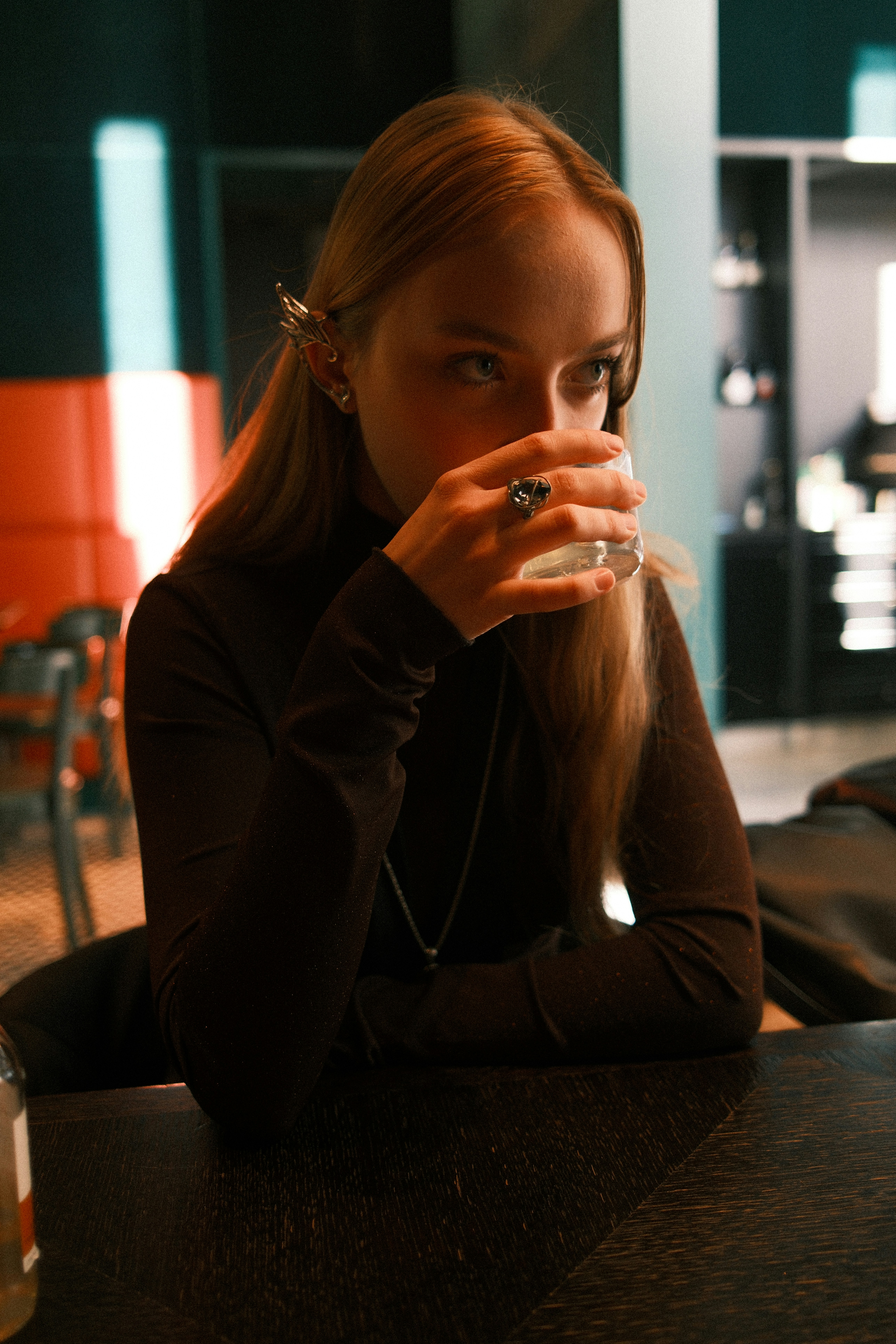 Young woman drinks from glass at a table