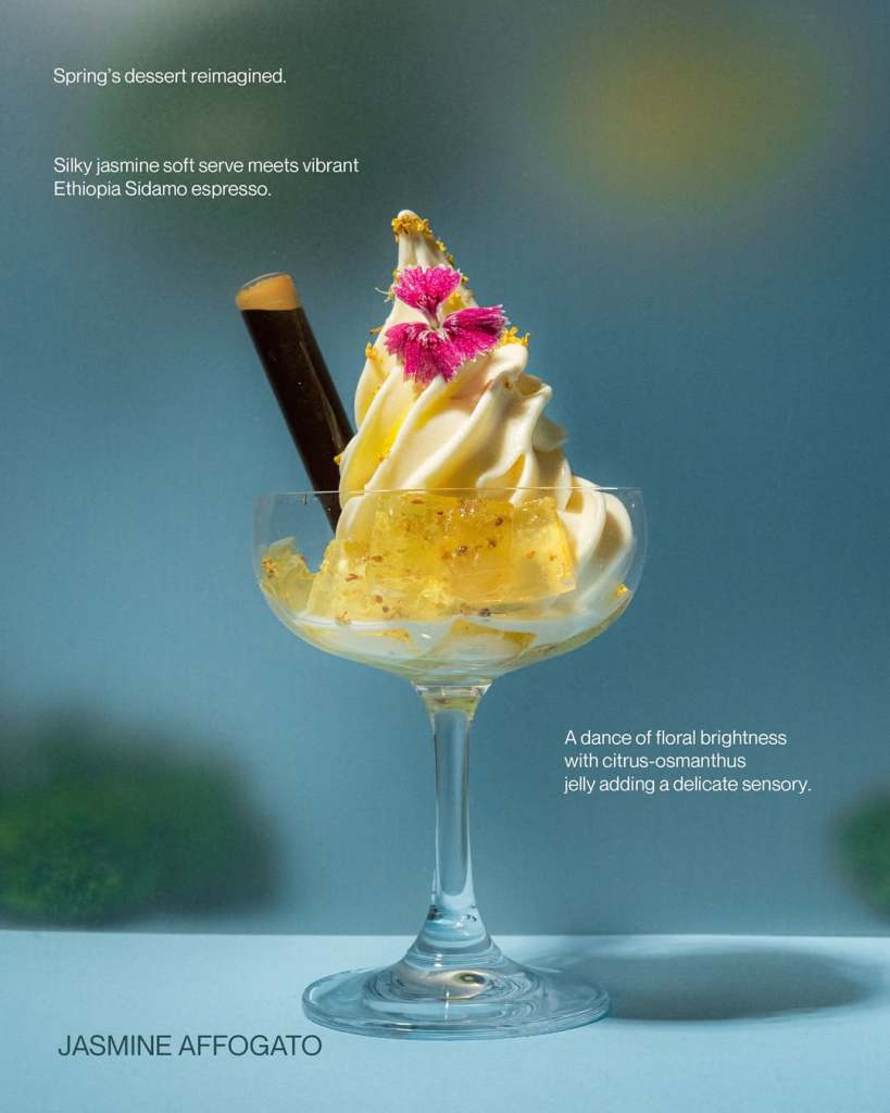 A glass dessert featuring silky jasmine soft serve topped with vibrant Ethiopia Sidamo espresso, decorated with a purple flower and citrus-osmanthus jelly.