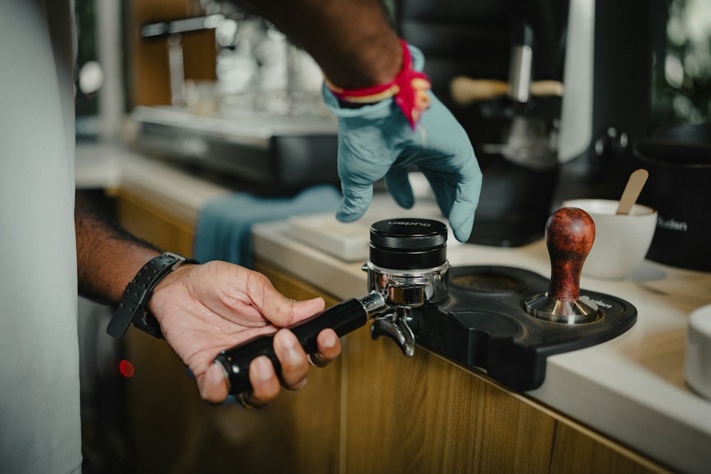 A barista levelling coffee in the portafilter