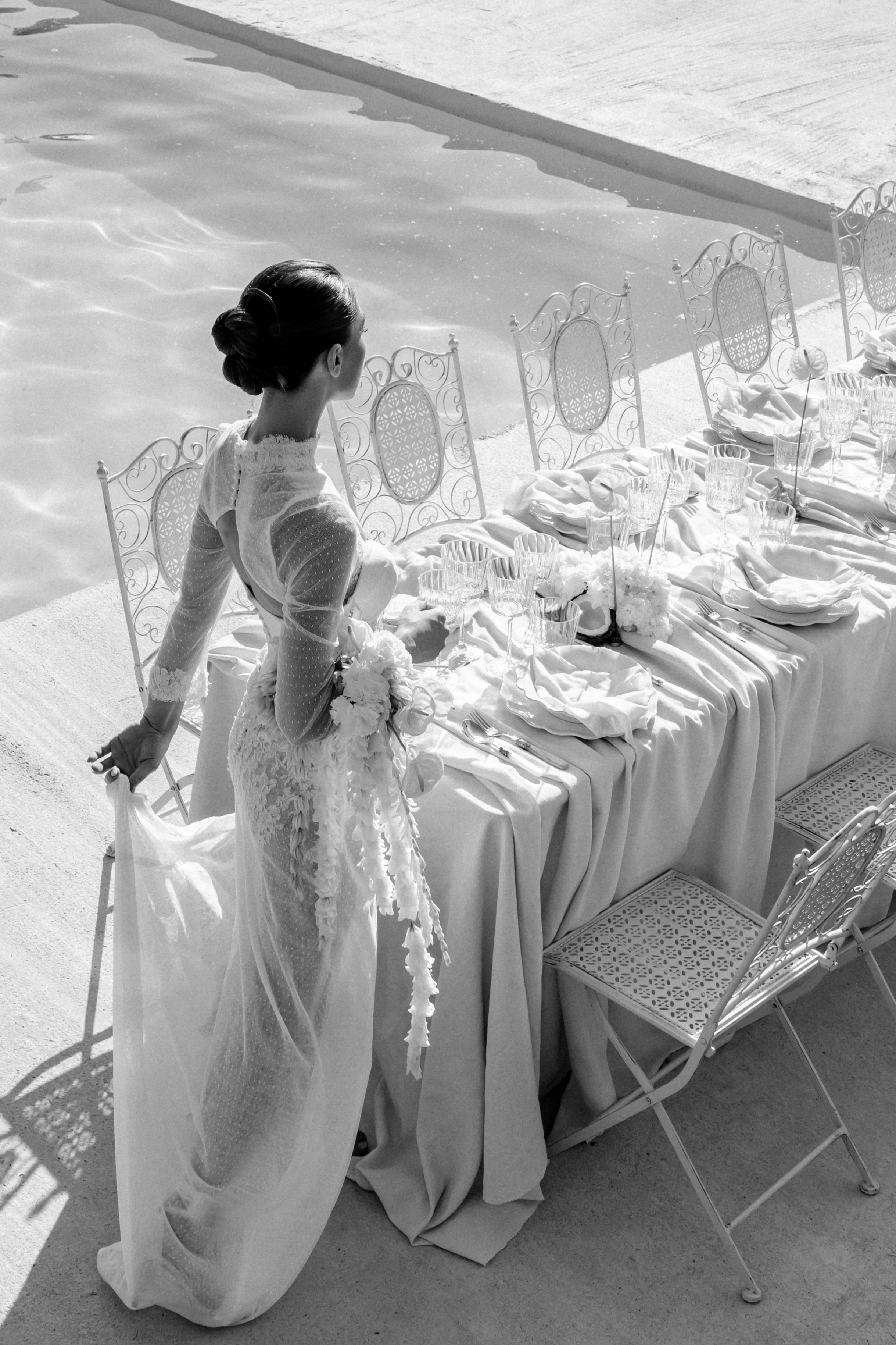 A bride and groom share a kiss surrounded by a joyful bridal party.
