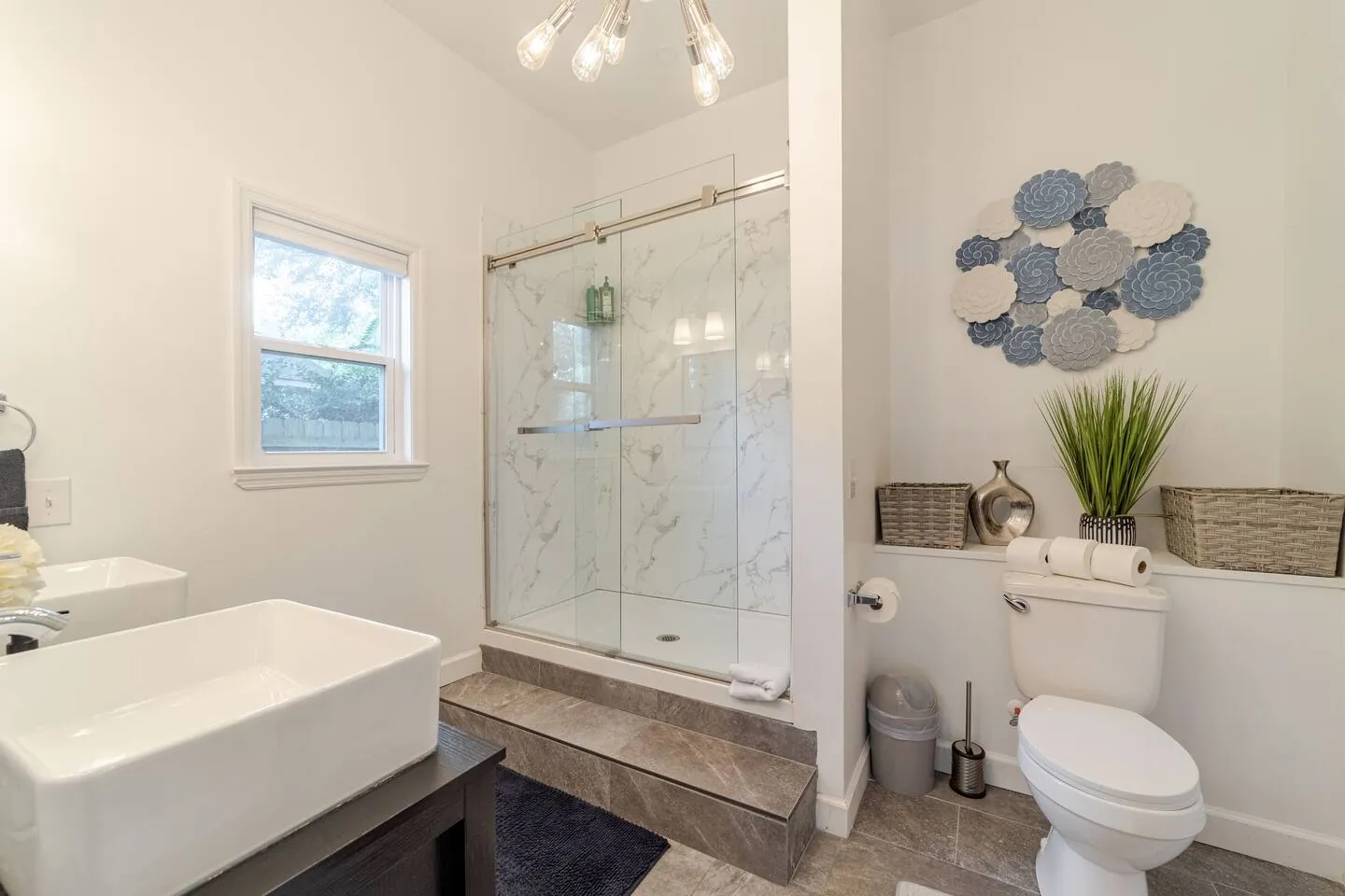 Walk-in glass shower and vessel sink in an en-suite bathroom