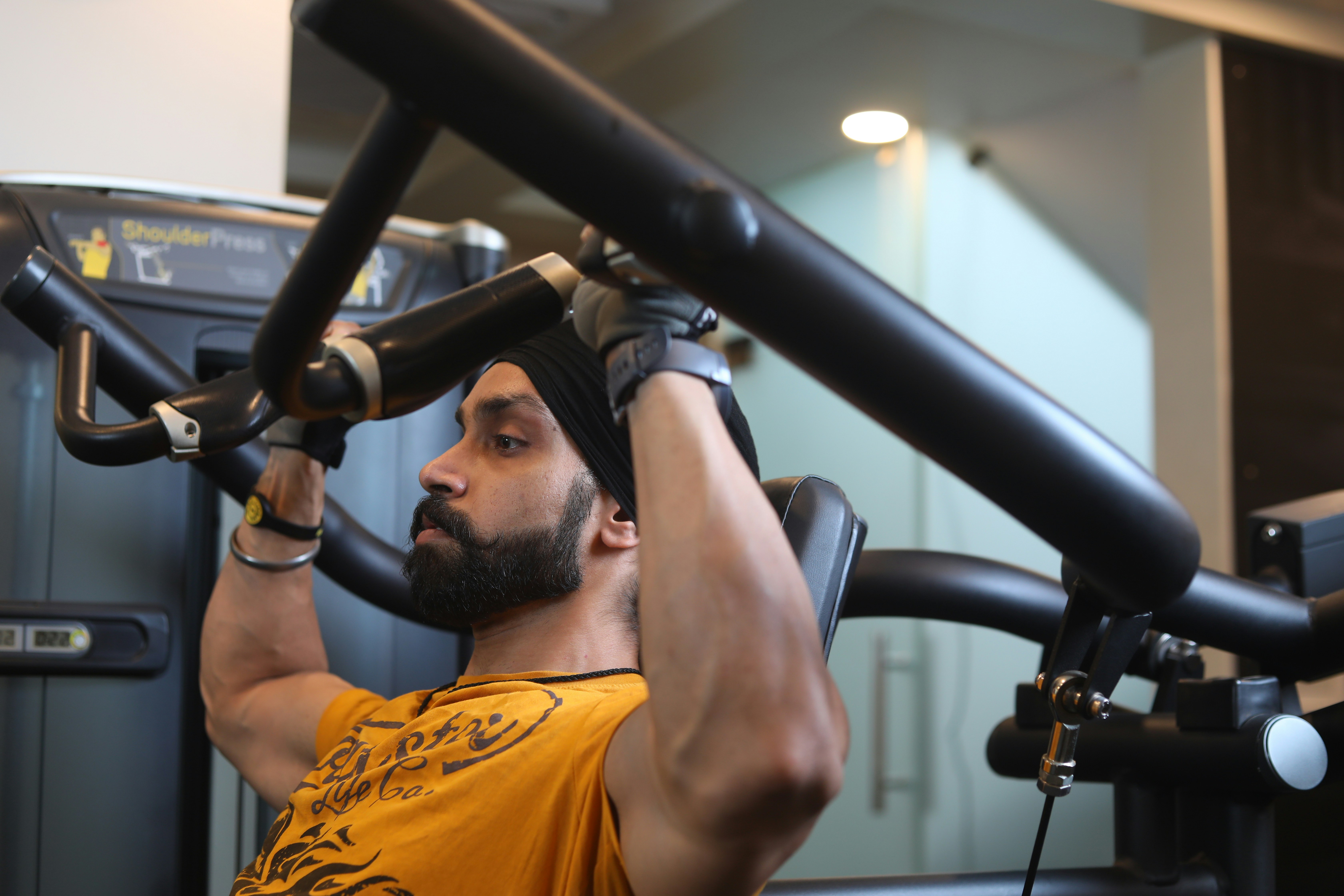 Young muscular man using fitness machine