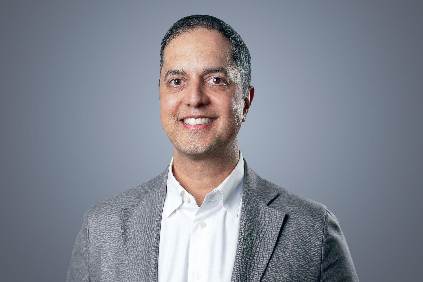 Samir Acharya, SteriMax President and CEO: Smiling in professional business attire against a neutral studio background.