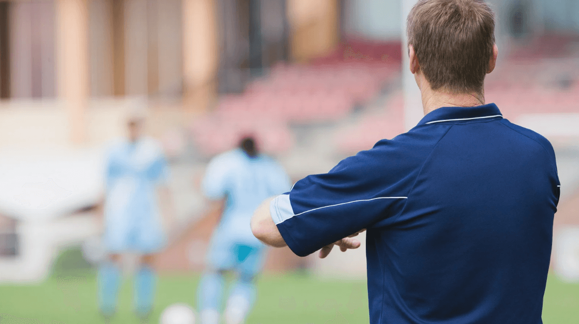 woman in blue tank top standing beside white wall