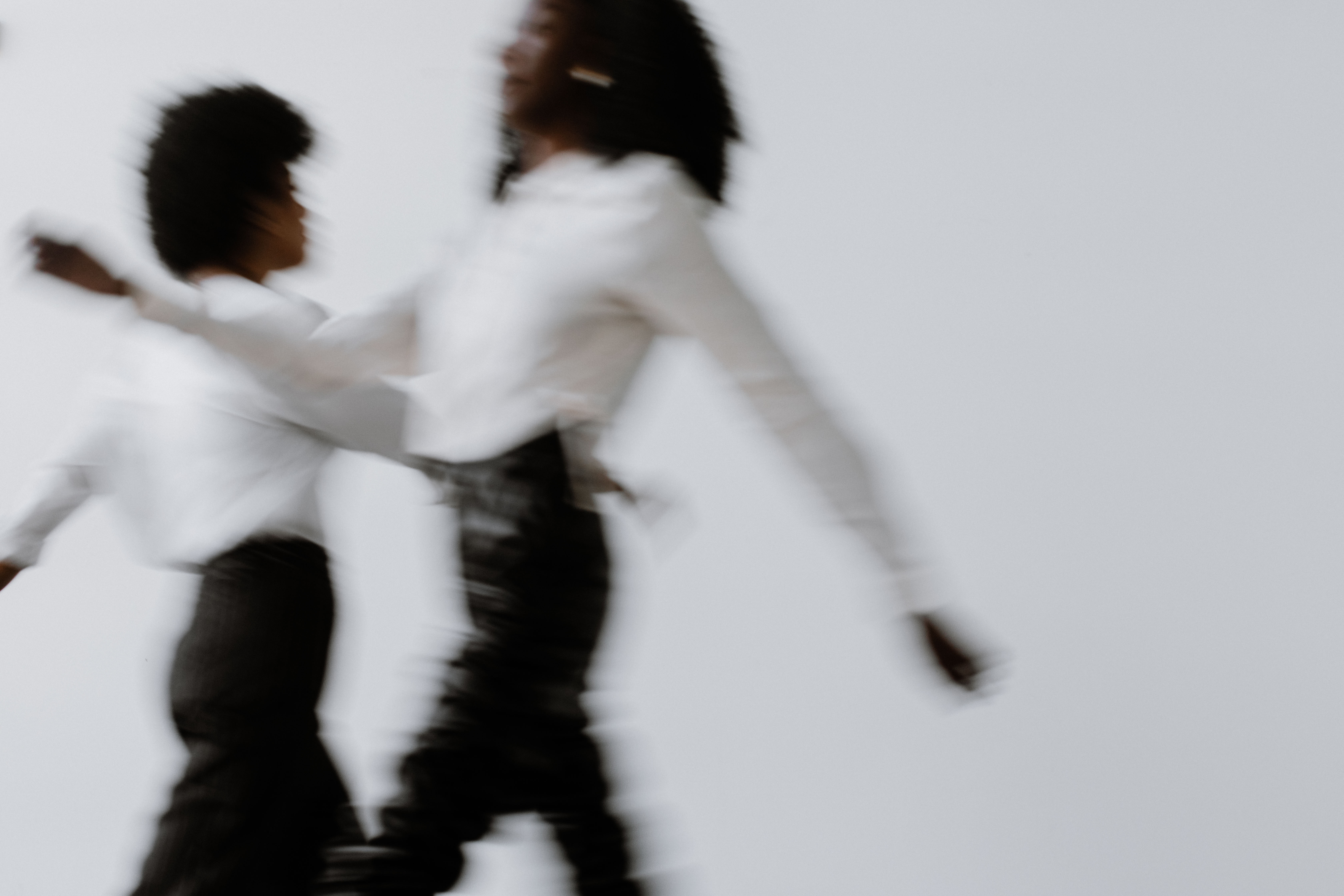 Two hands in an elegant gesture, one above the other, against a dark background