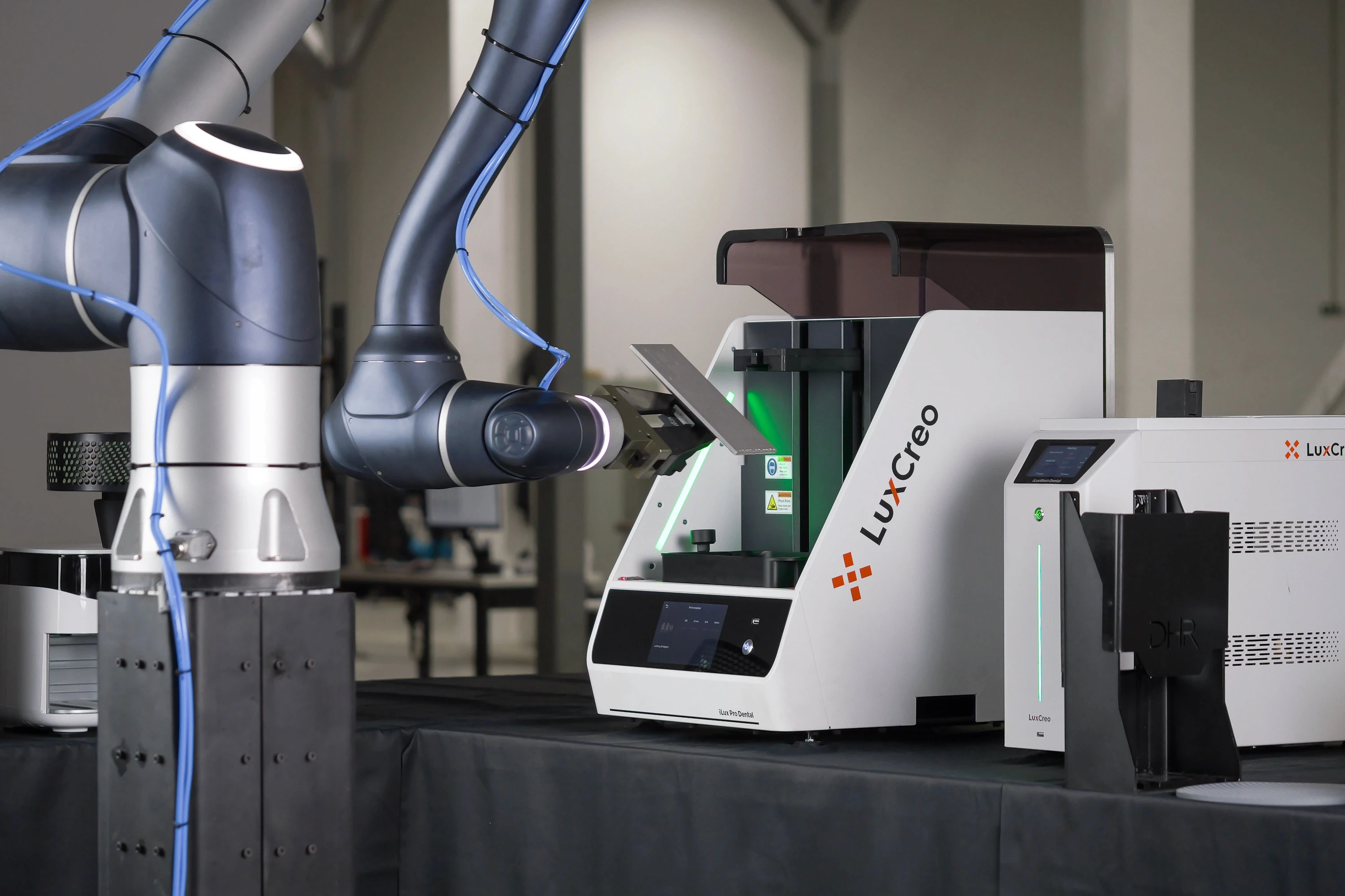 Robot arm placing a clean build platform with for 3D printed aligners from the LuxCreo iLux Pro Dental printer.