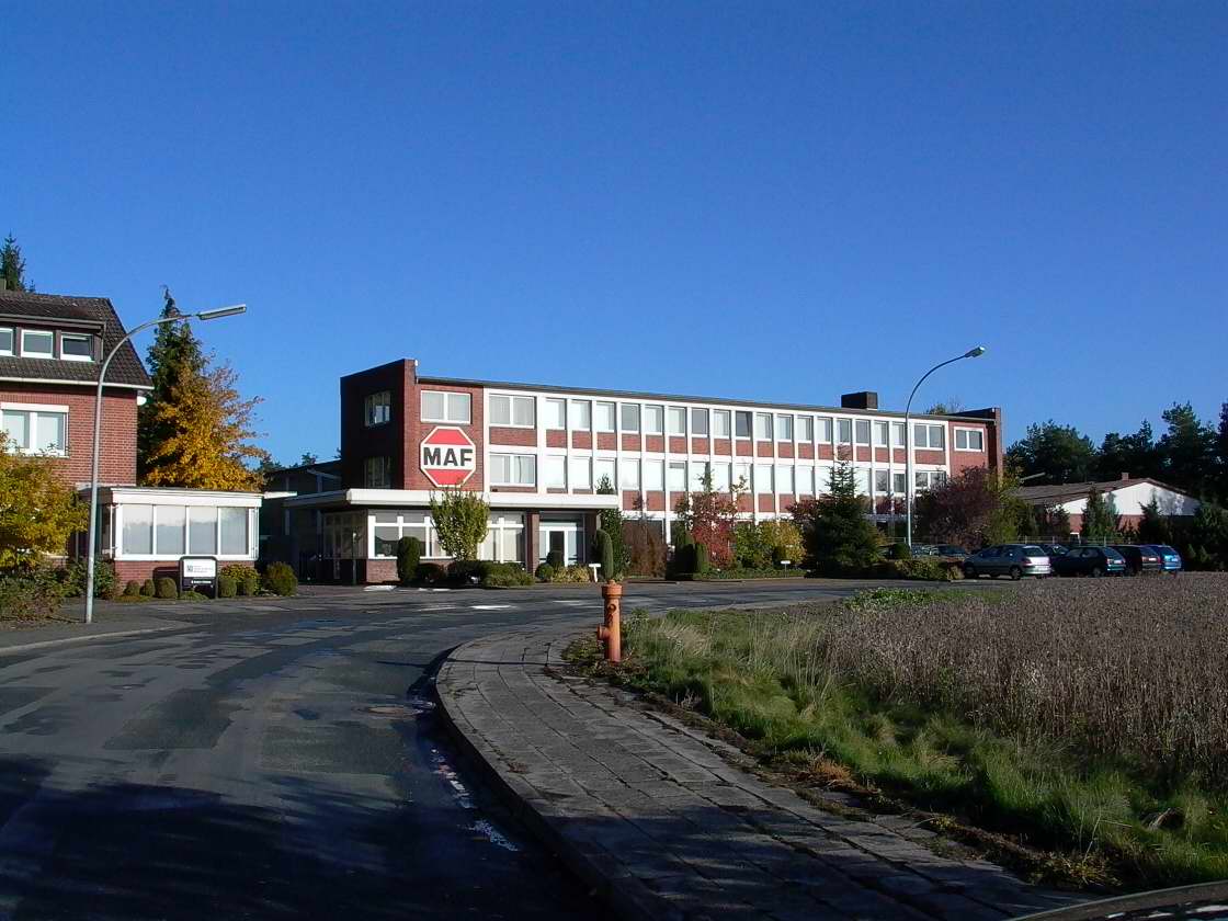 Industriegebäude mit M&S Logo, rotem Backsteinbau, blauer Himmel, Außenansicht