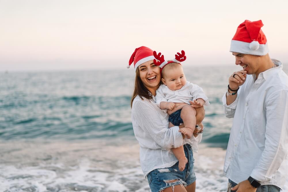 family wearing Santa hats during a Santa Cruz Christmas getaway at the beach