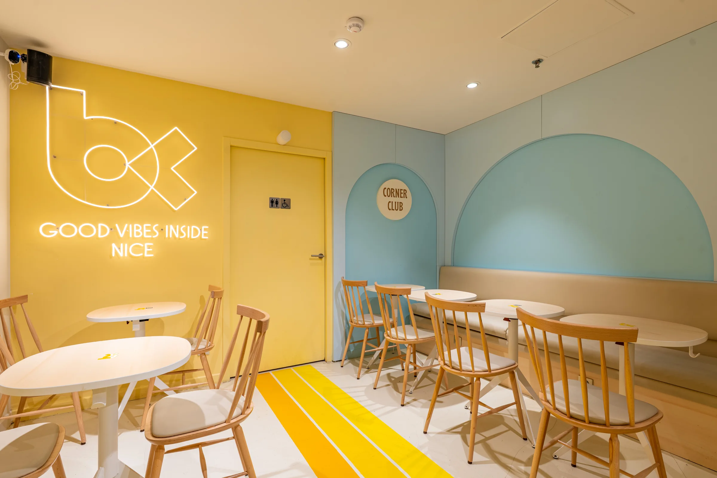 Bagel Corner interior with a yellow wall and blue arch — Nice, France. Photography by Yunes Calore.