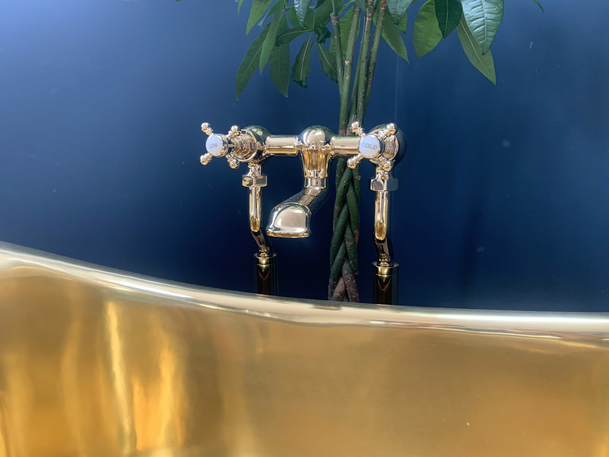 Brass mixer tap over luxury gold bath