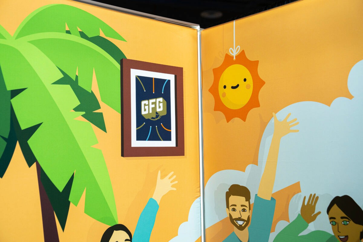 Corner view of the Gamers Outreach booth highlighting a picture frame with the Gamers for Giving logo, and the Team Sunny mascot from VTuber Summer Slam